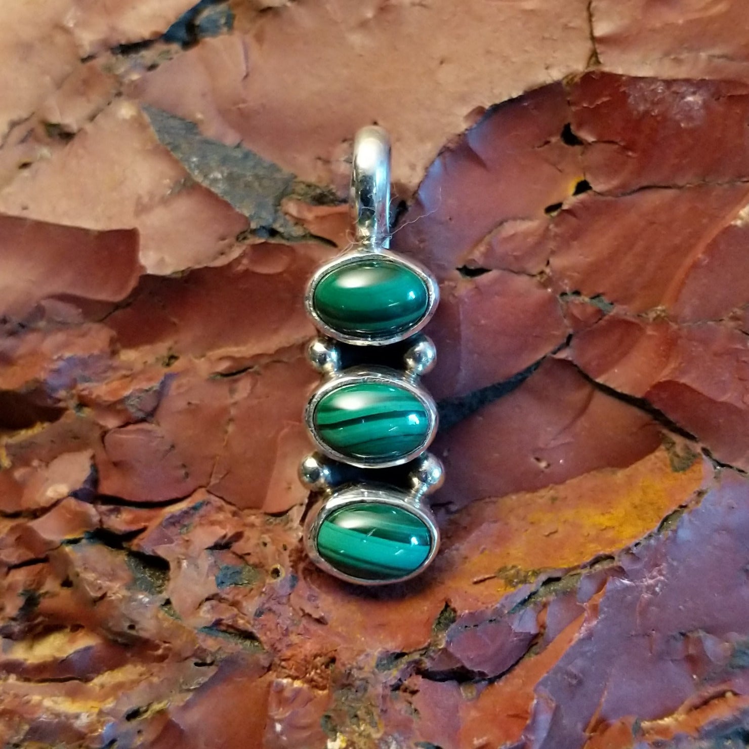 Stacked pendant with malachite set within the bezels.