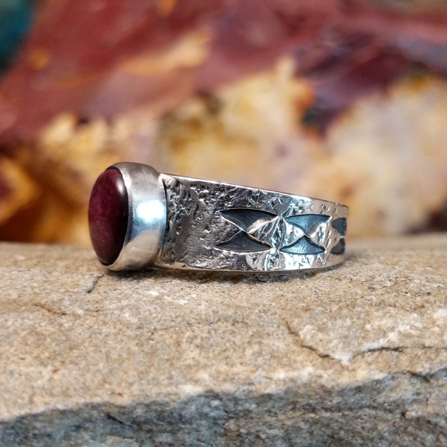Purple spiny oyster shell set in a smooth bezel on a textured and stamped base.