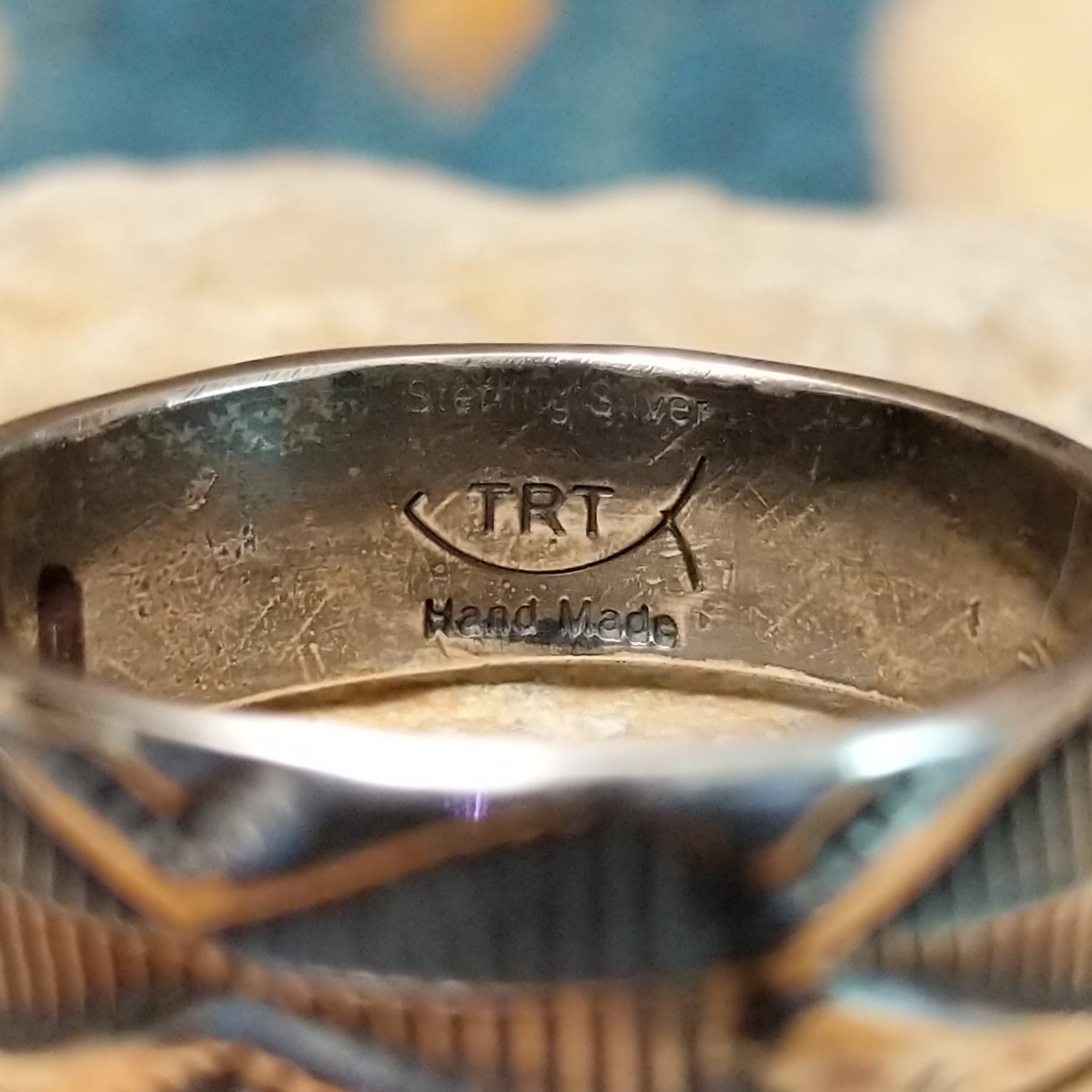 Handcrafted Navajo sterling silver stamped ring by Travis Teller featuring a wide band with deep traditional geometric stampwork and an oxidized finish; artisan and Sterling Silver stamp.
