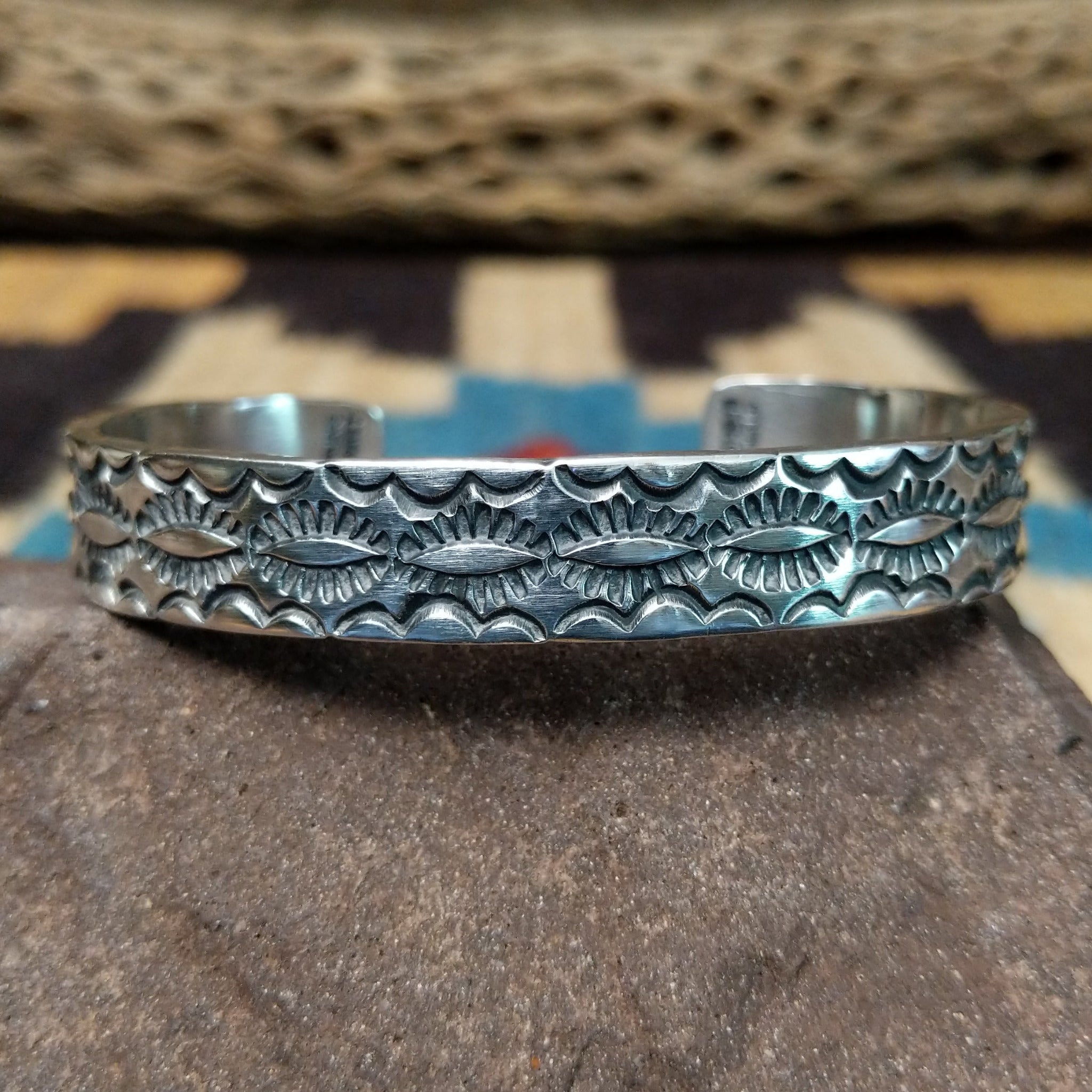 Stamped sterling silver cuff by B. Shorty, featuring intricate hand-stamped geometric and floral-inspired patterns on a handcrafted open sterling silver cuff.