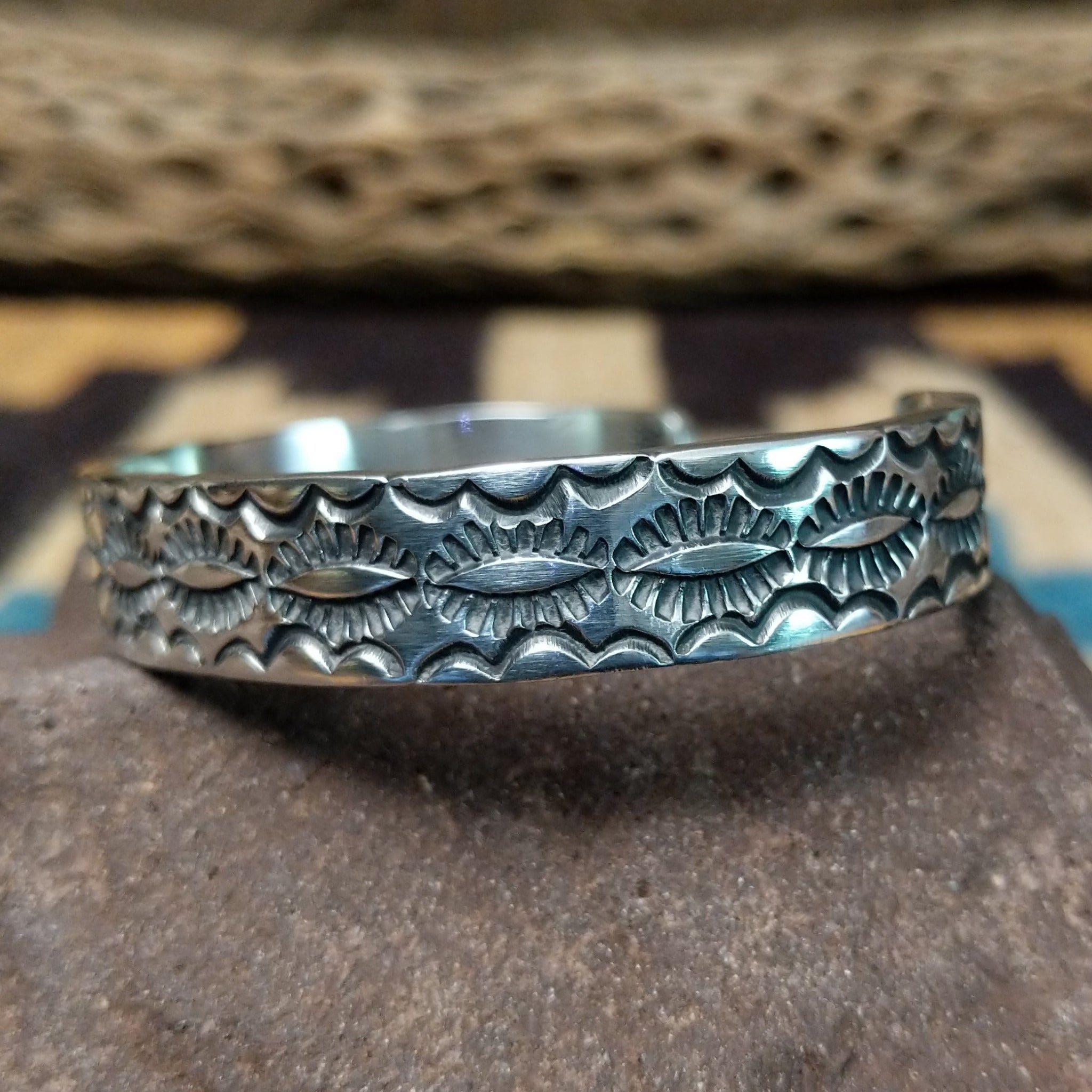 Stamped sterling silver cuff by B. Shorty, featuring intricate hand-stamped geometric and floral-inspired patterns on a handcrafted open sterling silver cuff.