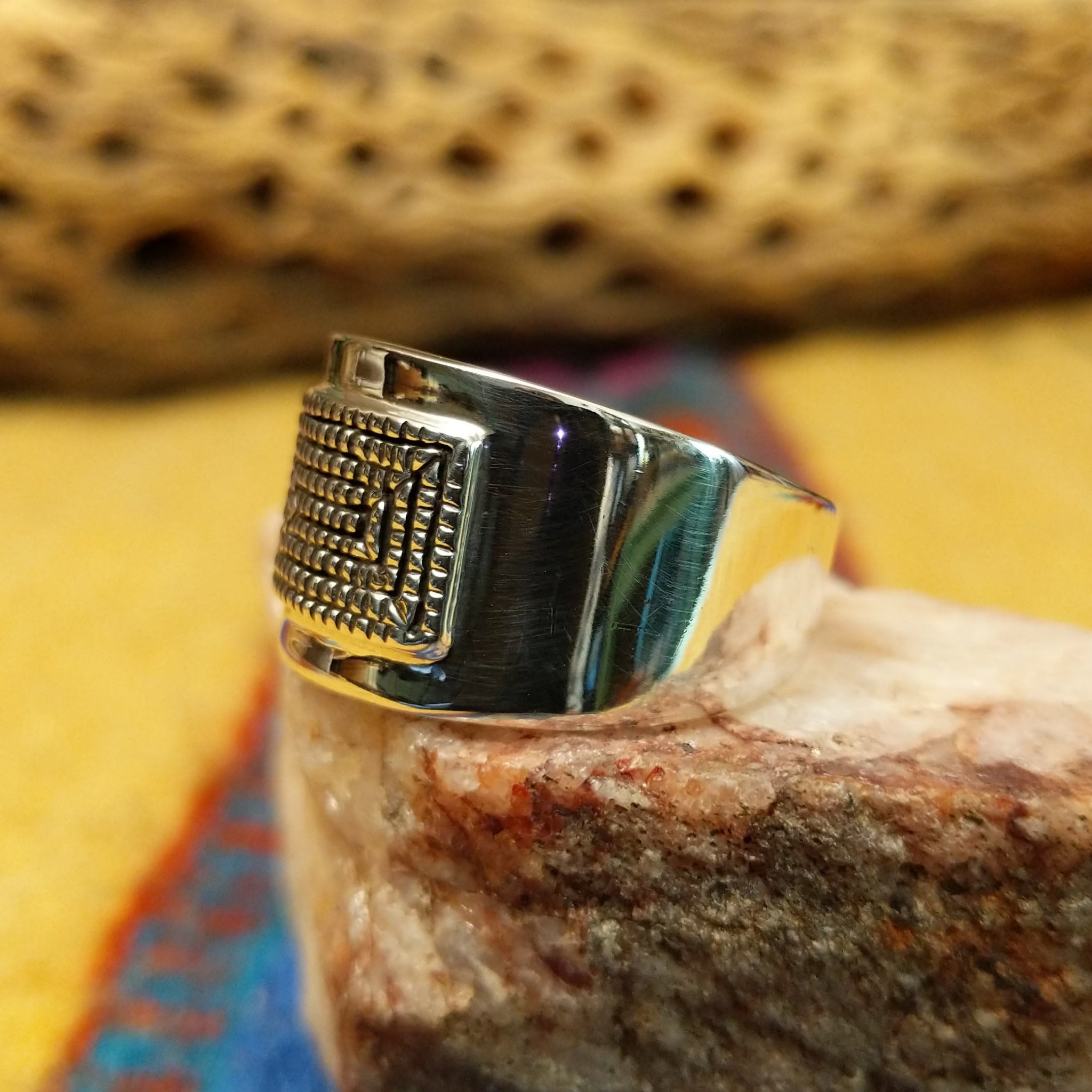 Stamped sterling silver ring by Raymond Coriz, featuring intricate hand-stamped patterns on a polished sterling silver band with traditional Southwestern-inspired craftsmanship. Side view.
