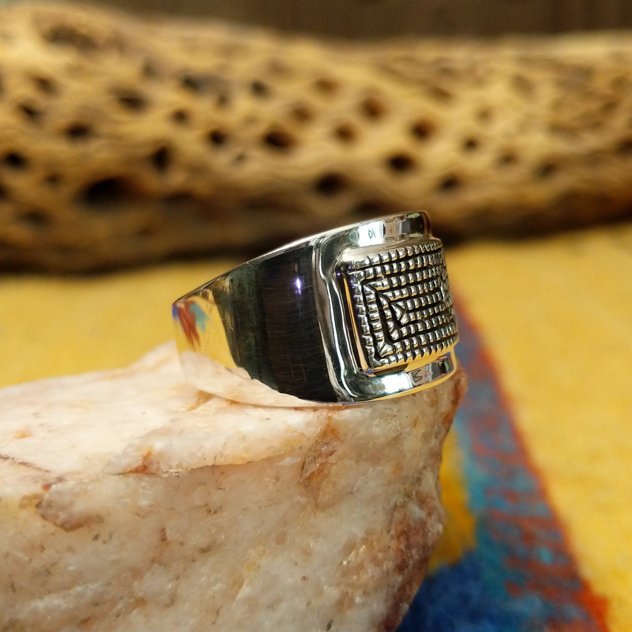 Stamped sterling silver ring by Raymond Coriz, featuring intricate hand-stamped patterns on a polished sterling silver band with traditional Southwestern-inspired craftsmanship. Side view.