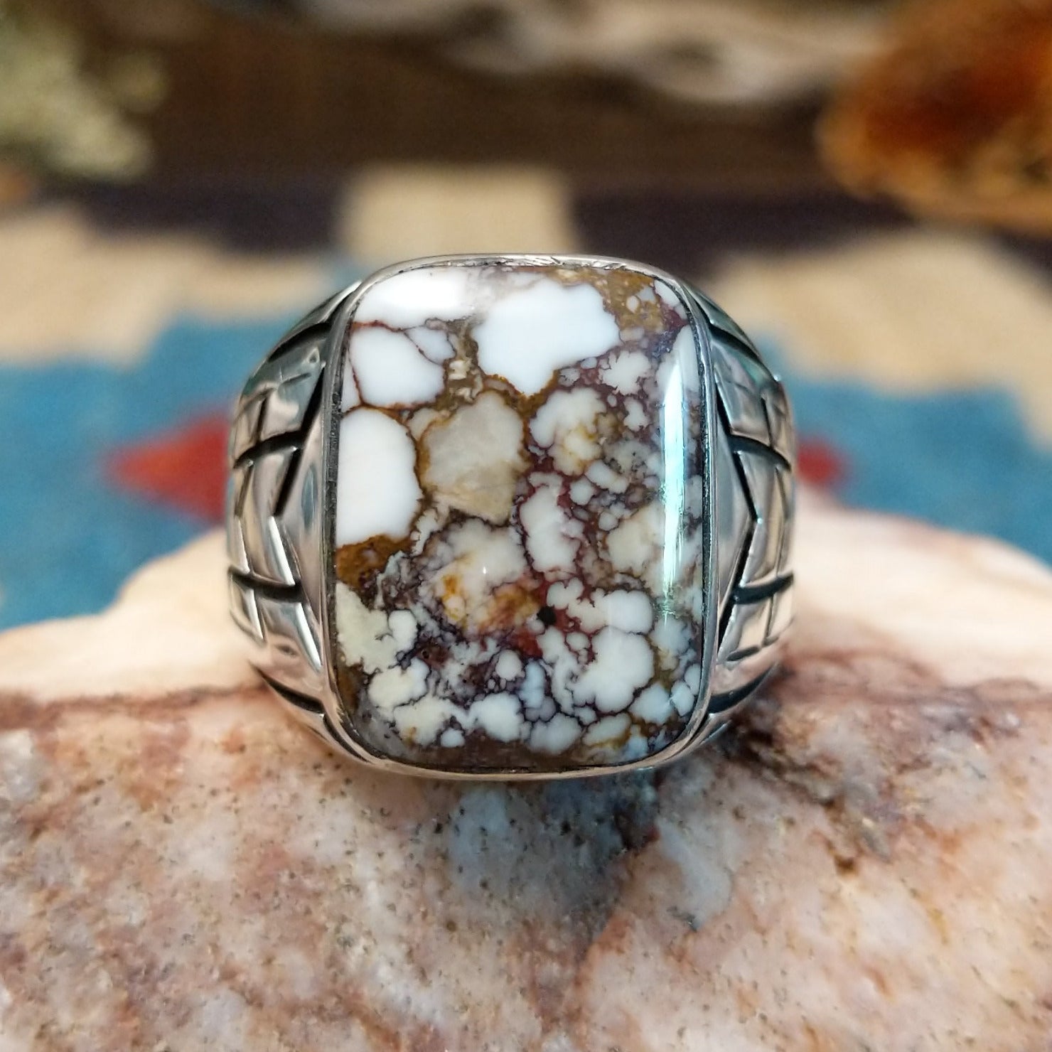 Sterling silver ring with wild horse stone set in the rectangular bezel and geometric stamping on the band.