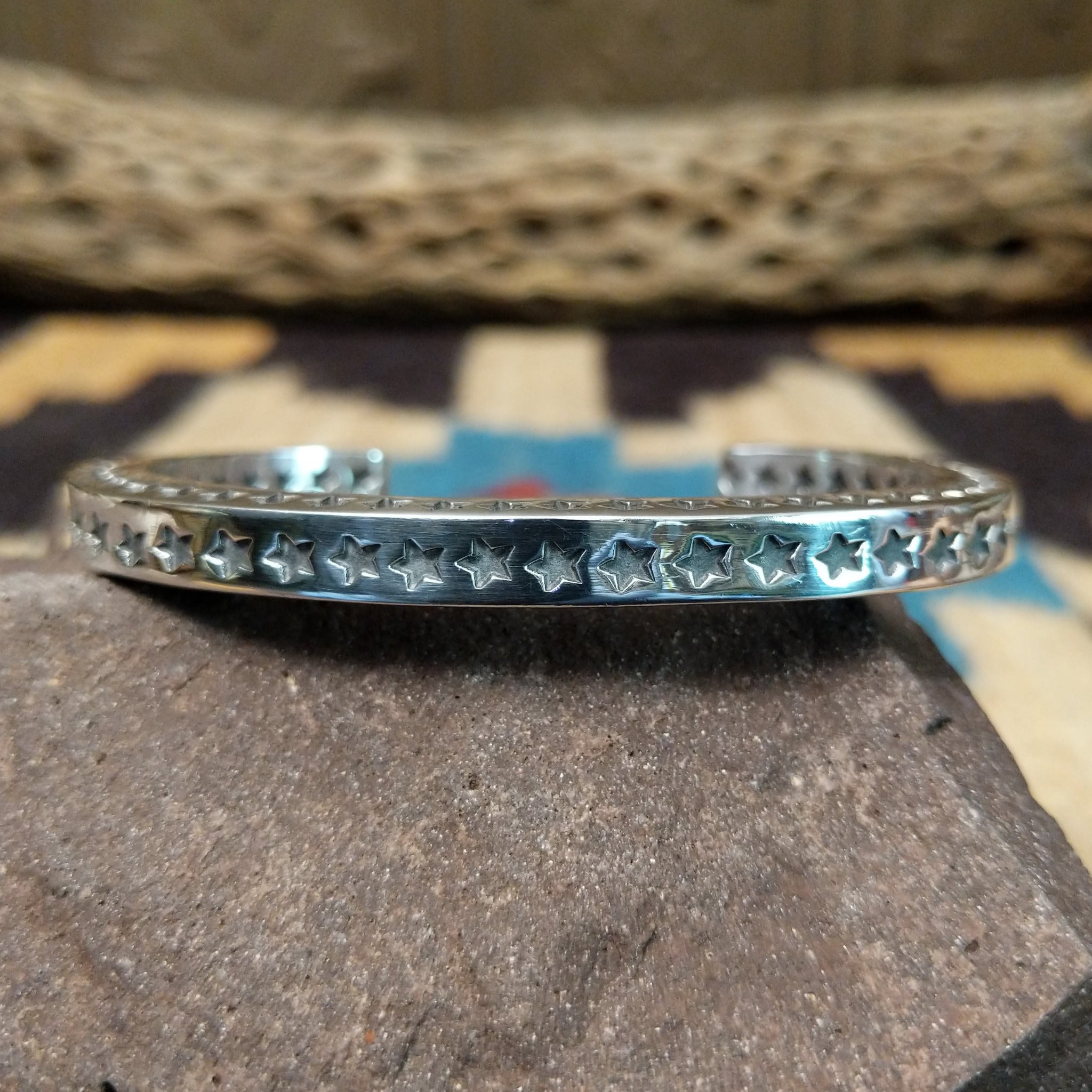 Starred sterling silver cuff by Sunshine Reeves, featuring hand-stamped star motifs and intricate geometric patterns on a handcrafted open sterling silver cuff.