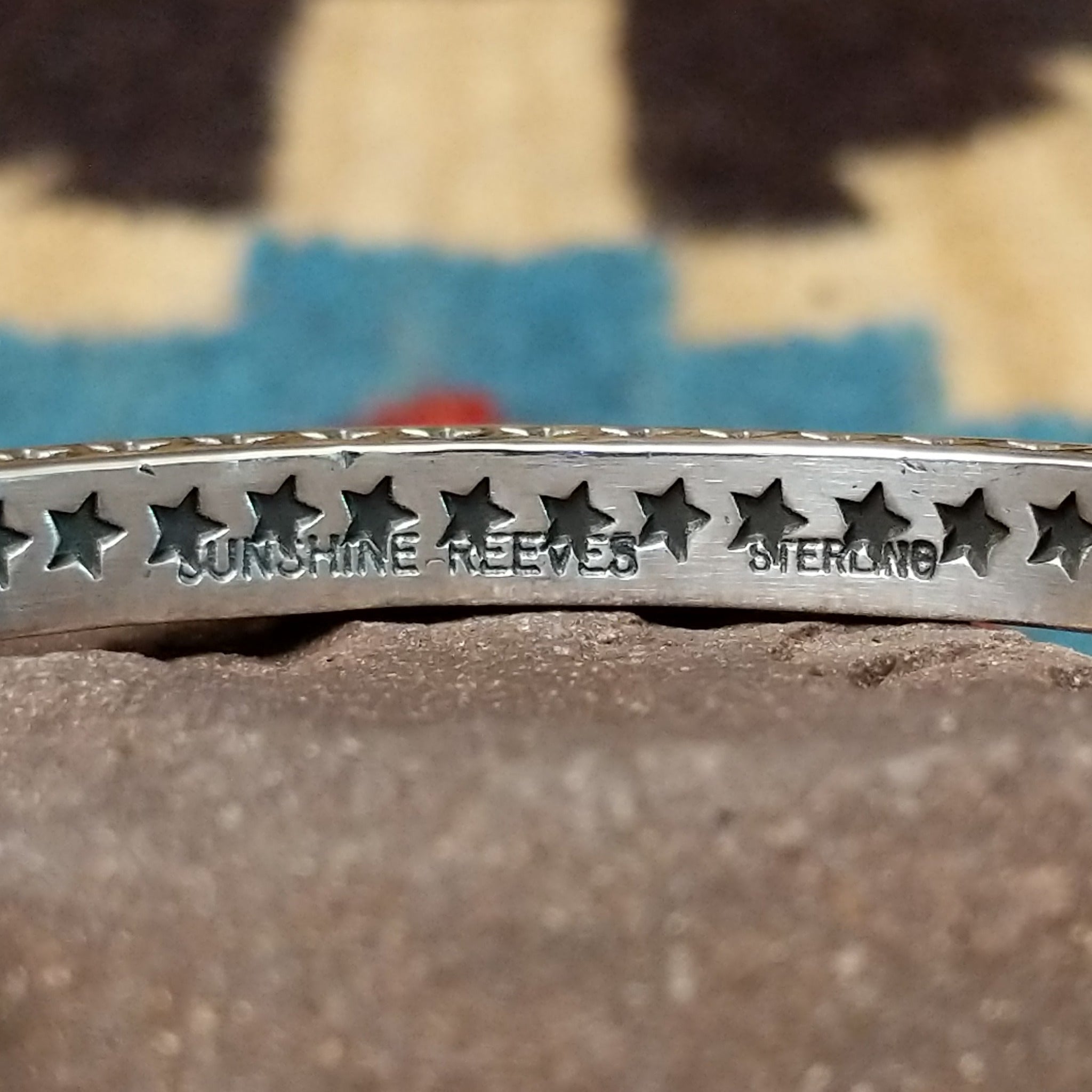 Starred sterling silver cuff by Sunshine Reeves, featuring hand-stamped star motifs and intricate geometric patterns on a handcrafted open sterling silver cuff. Artisan and Sterling Silver stamp.