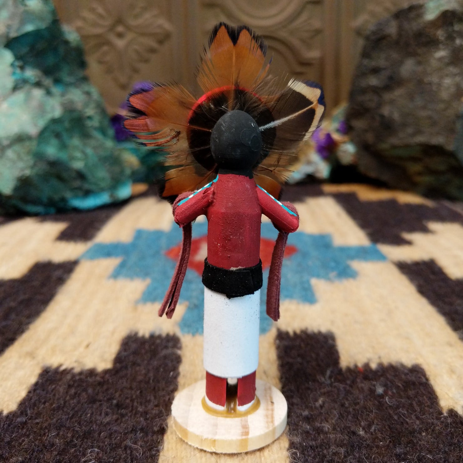 Mini Sunface kachina by Rosalind Grey with turquoise circular face, feathered halo, and white geometric-patterned garment.