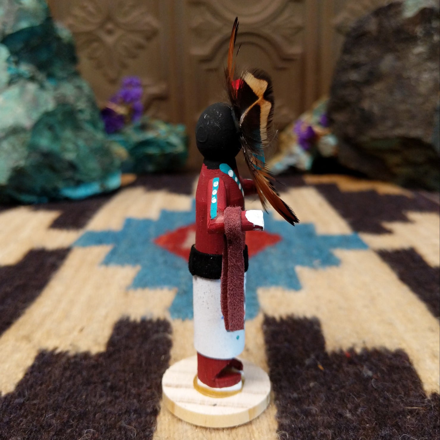 Mini Sunface kachina by Rosalind Grey with turquoise circular face, feathered halo, and white geometric-patterned garment.
