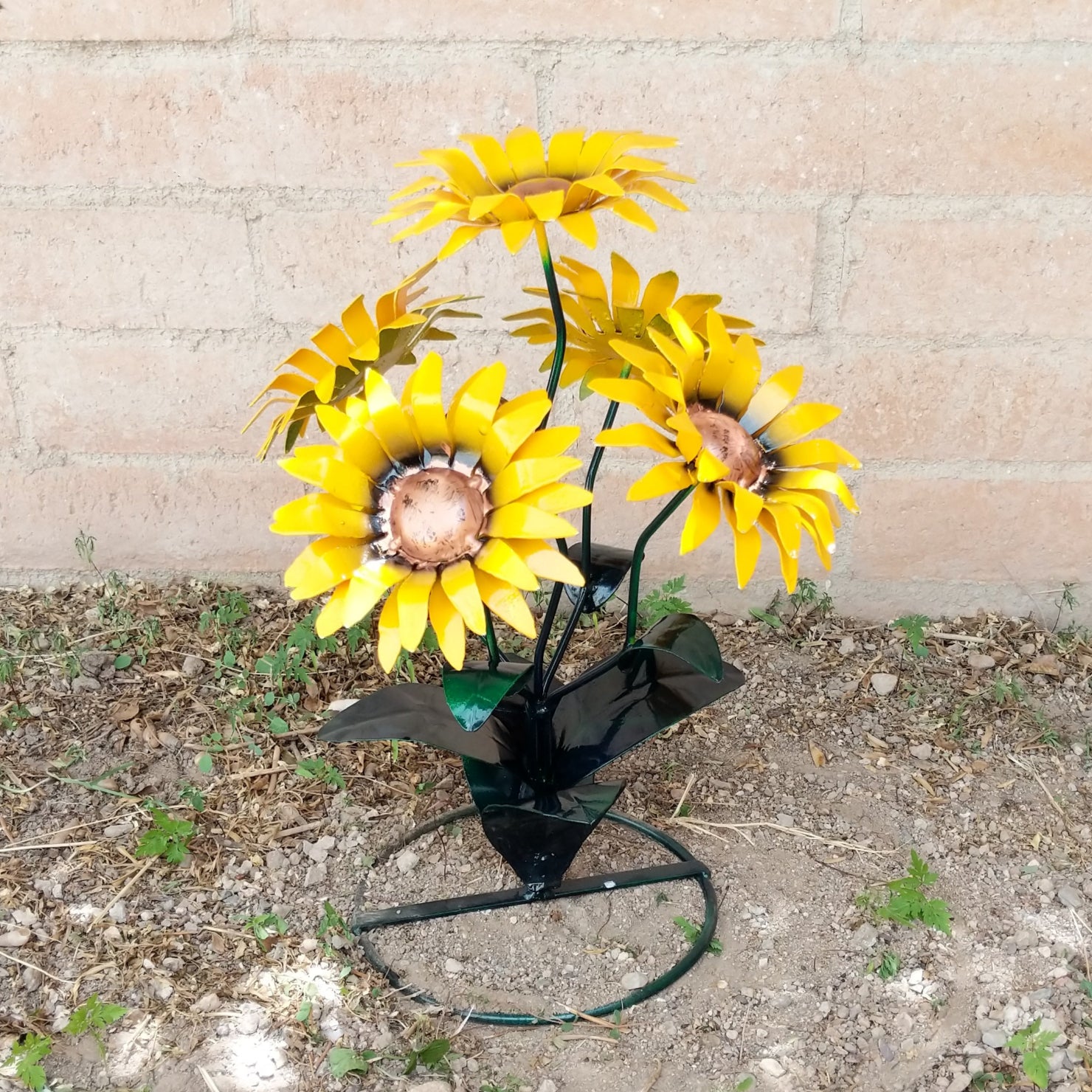 A metal sunflower bouquet with bright yellow petals and copper centers on black-green stems.