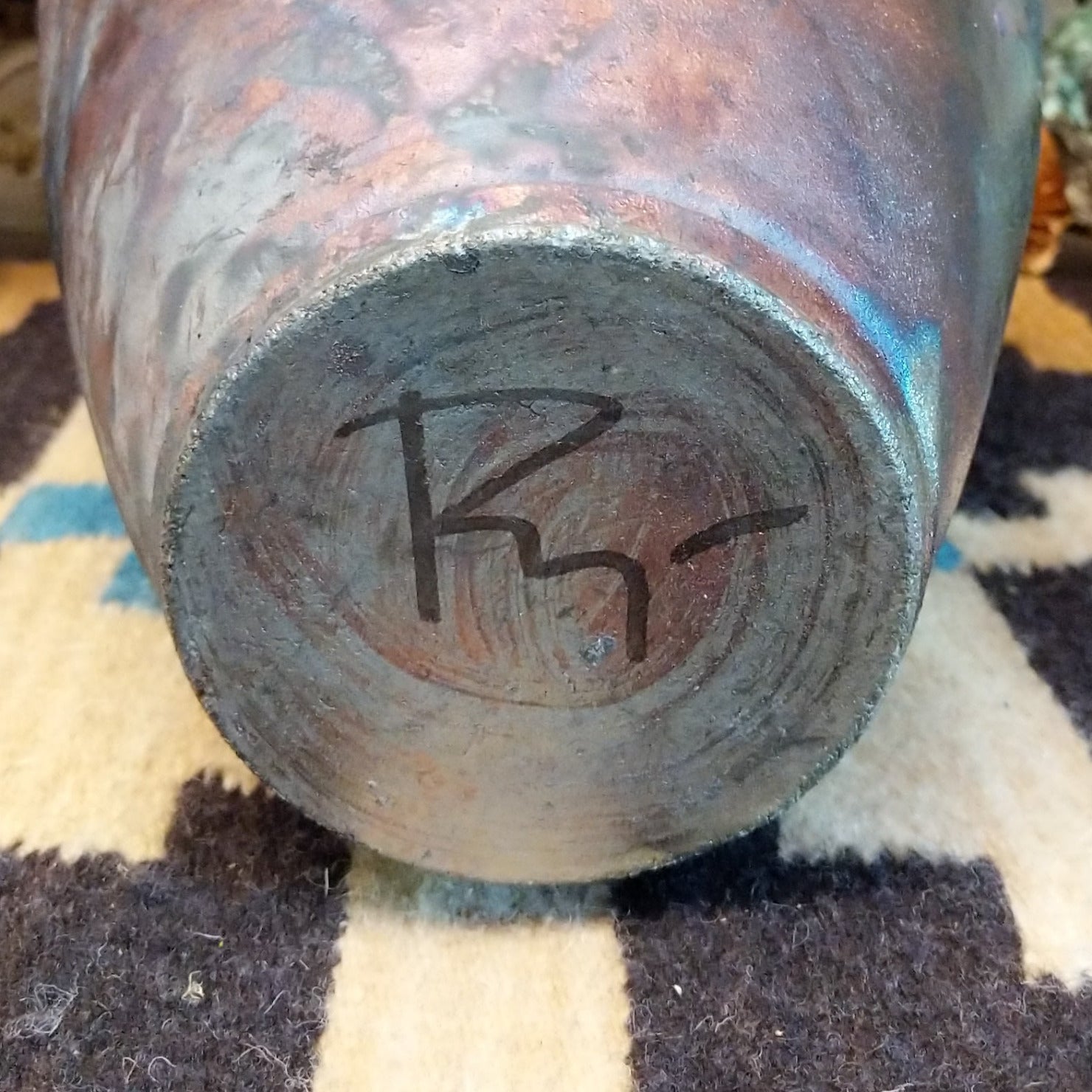 Close-up of the artisan's signature on the base.