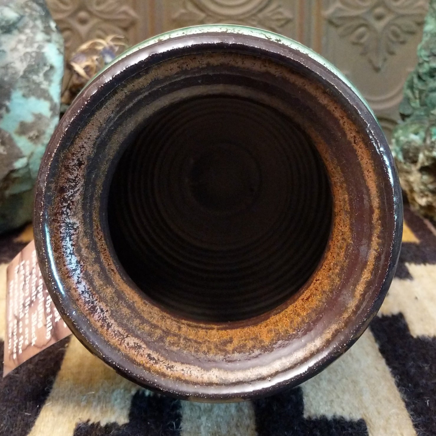 Close-up of the earth-toned lip of the piece.