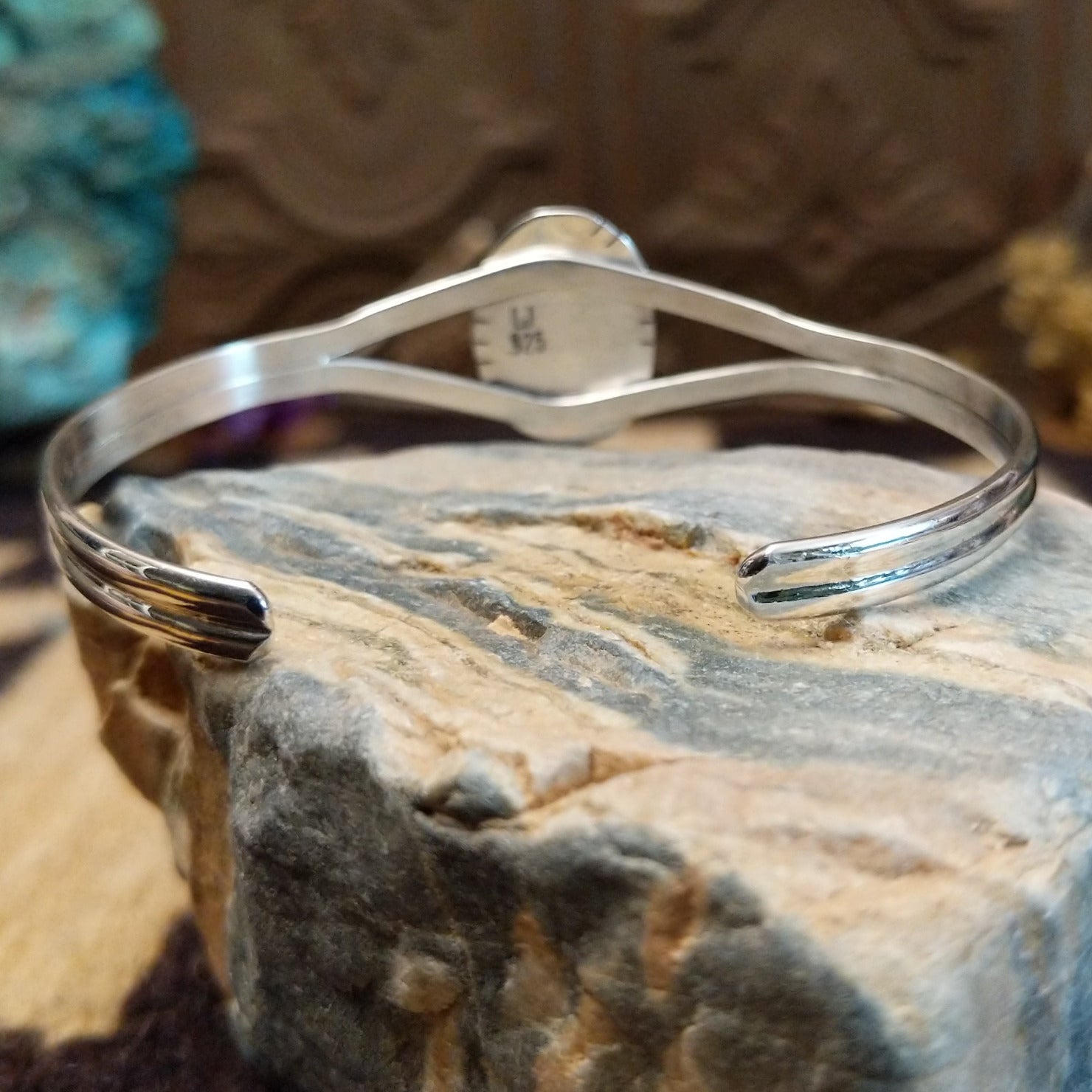 Sterling silver cuff with turquoise set in an oval bezel, framed by twisted rope and incised setting.