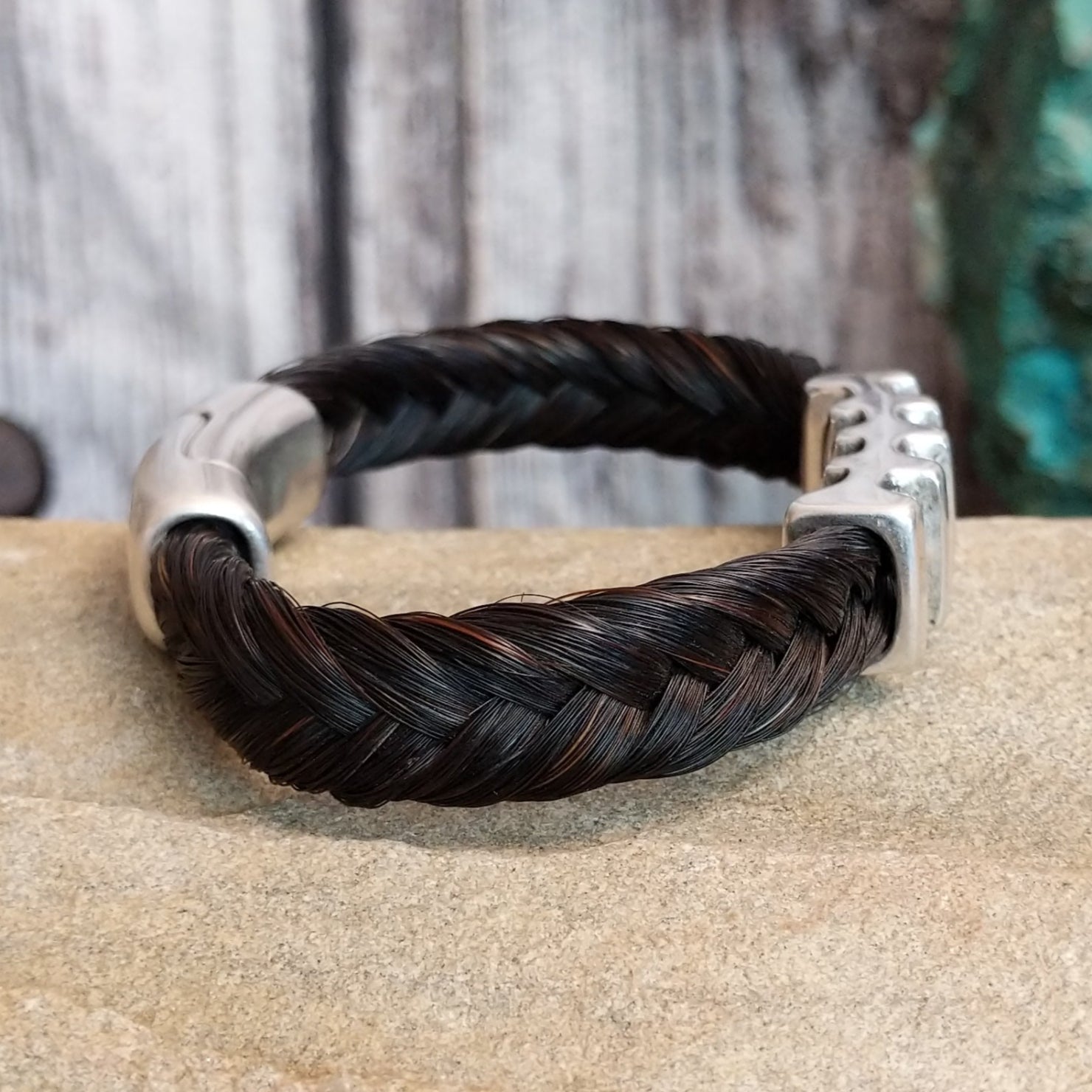 Braided dark brown horsehair bracelet with a metal grille accent and a magnetic clasp.