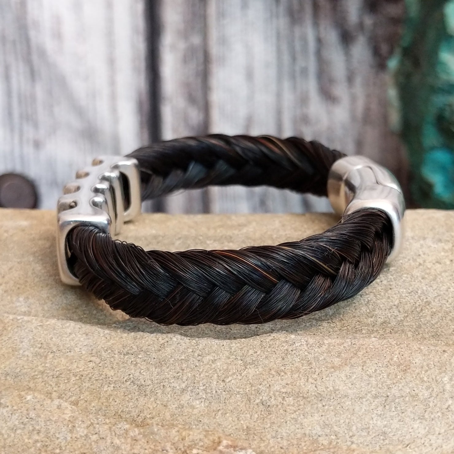Braided dark brown horsehair bracelet with a metal grille accent and a magnetic clasp.