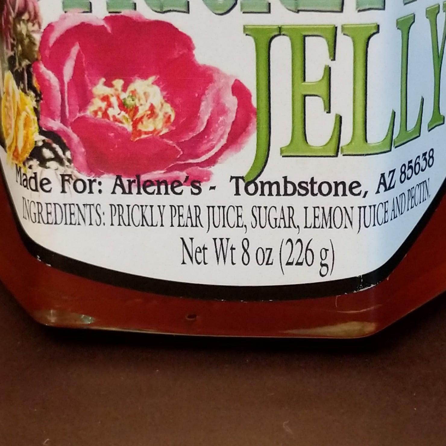 Jar of Tombstone Prickly Pear Jelly with a bright pink-purple color. Southwestern-style fruit jelly made from prickly pear cactus, ideal for spreading on toast, biscuits, or pairing with cheese.