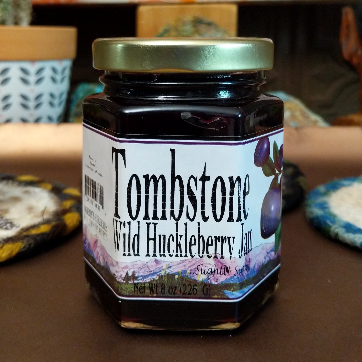 Jar of Tombstone Wild Huckleberry Jam with a deep purple color. Small-batch fruit jam made from wild huckleberries, offering a sweet and slightly tart flavor, perfect for toast, pastries, or cheese pairings.