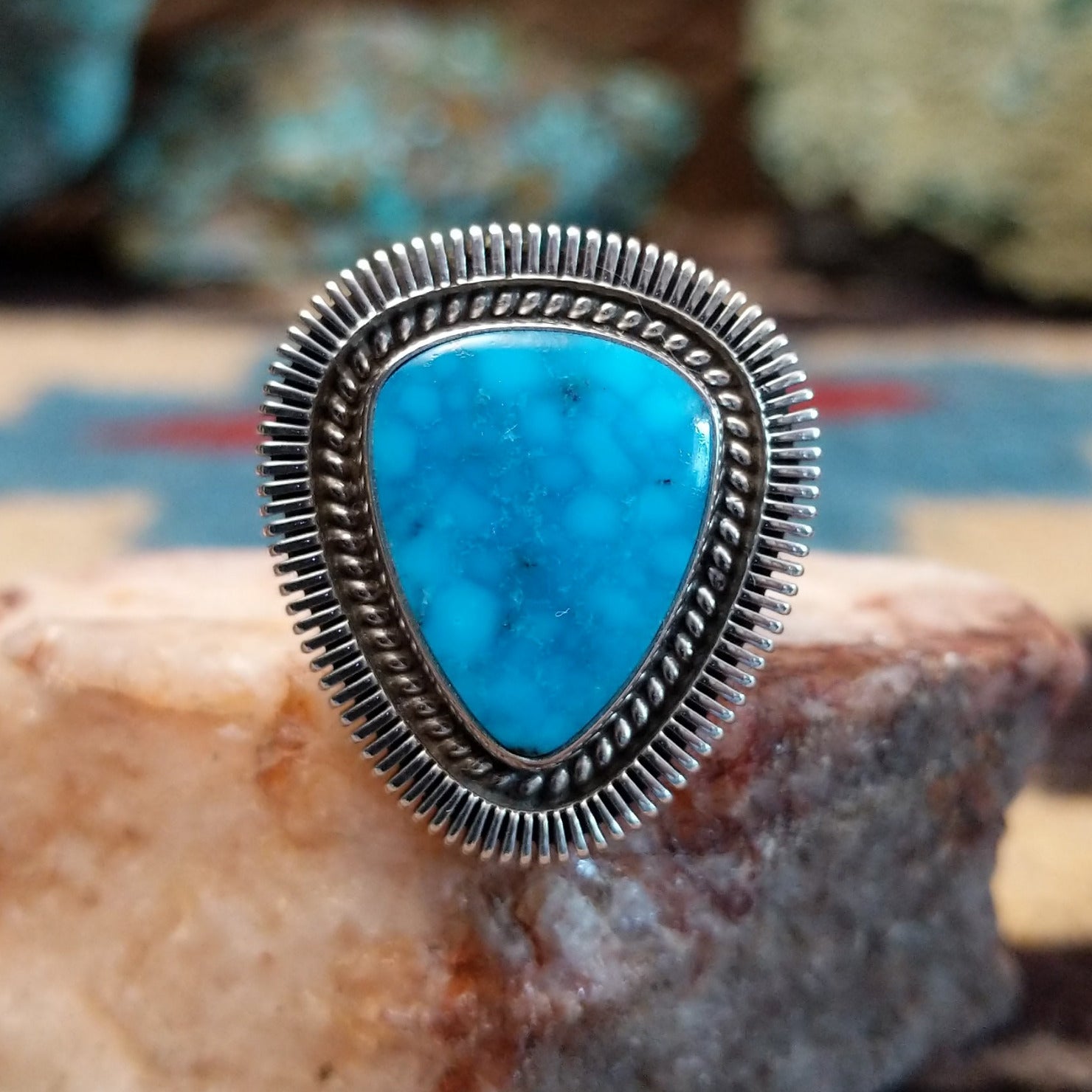 Sterling silver ring with triangular turquoise and twisted rope bezel.