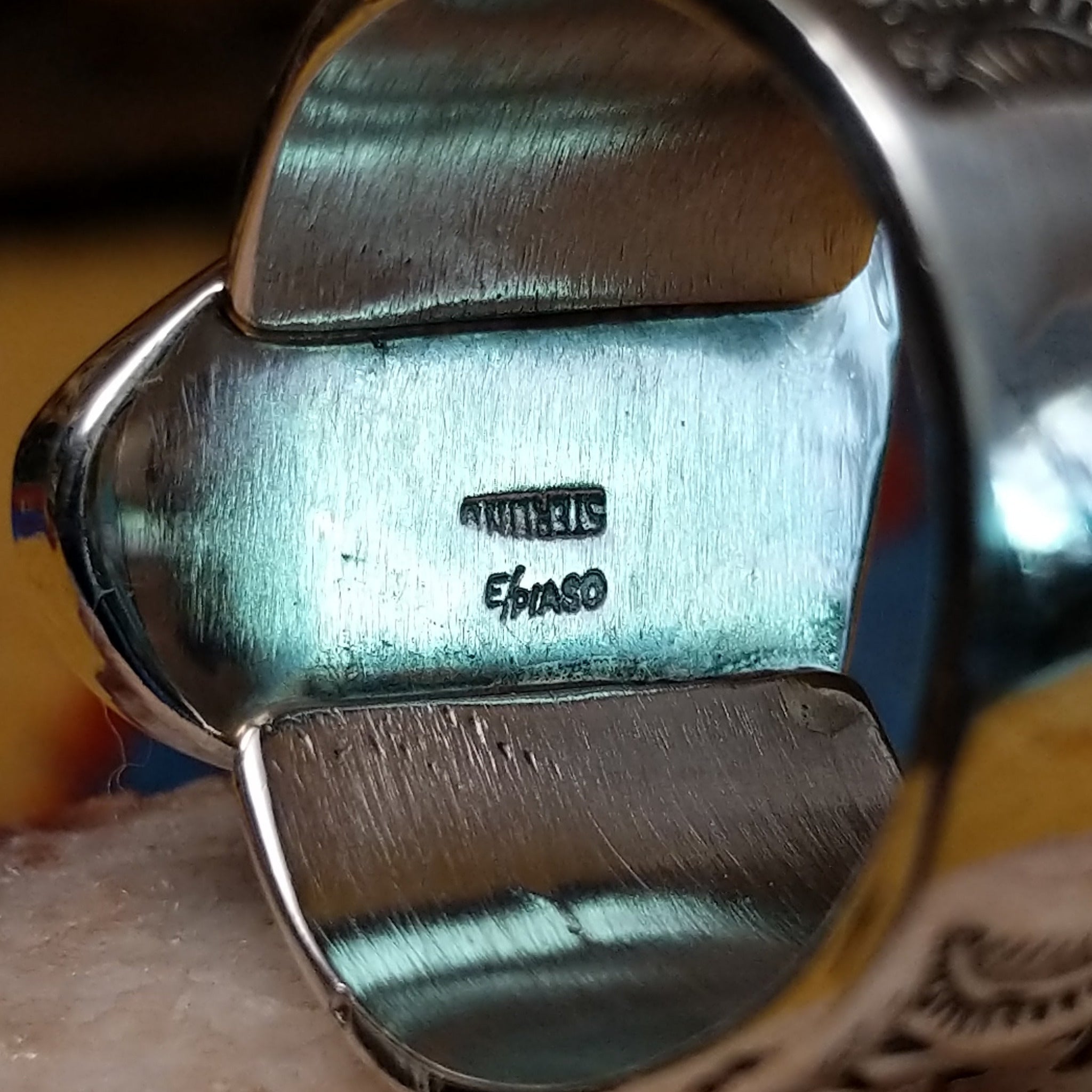 Triangular turquoise ring by E. Piaso, featuring a vibrant blue turquoise stone with natural matrix set in a handcrafted sterling silver band. Artisan and Sterling Silver stamp.