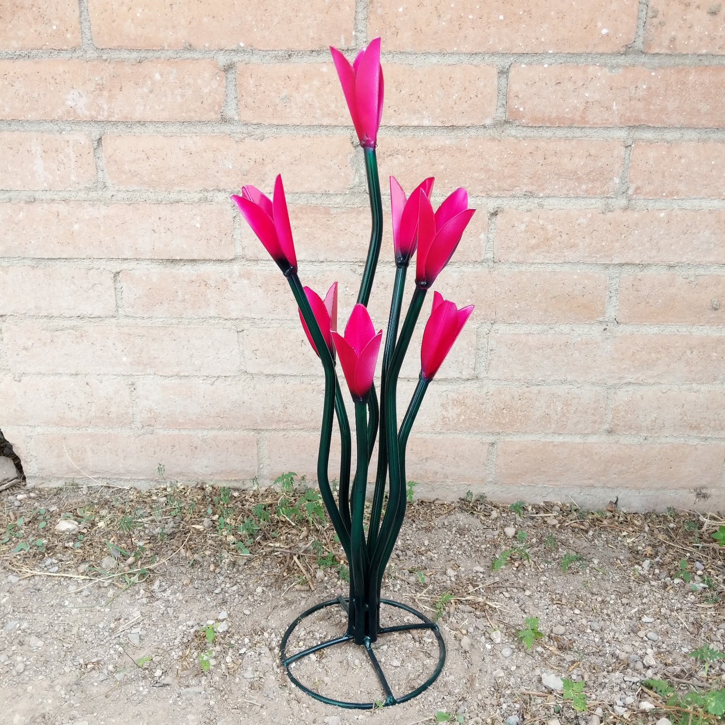 A medium metal tulip sculpture, with painted vivid pink petals.