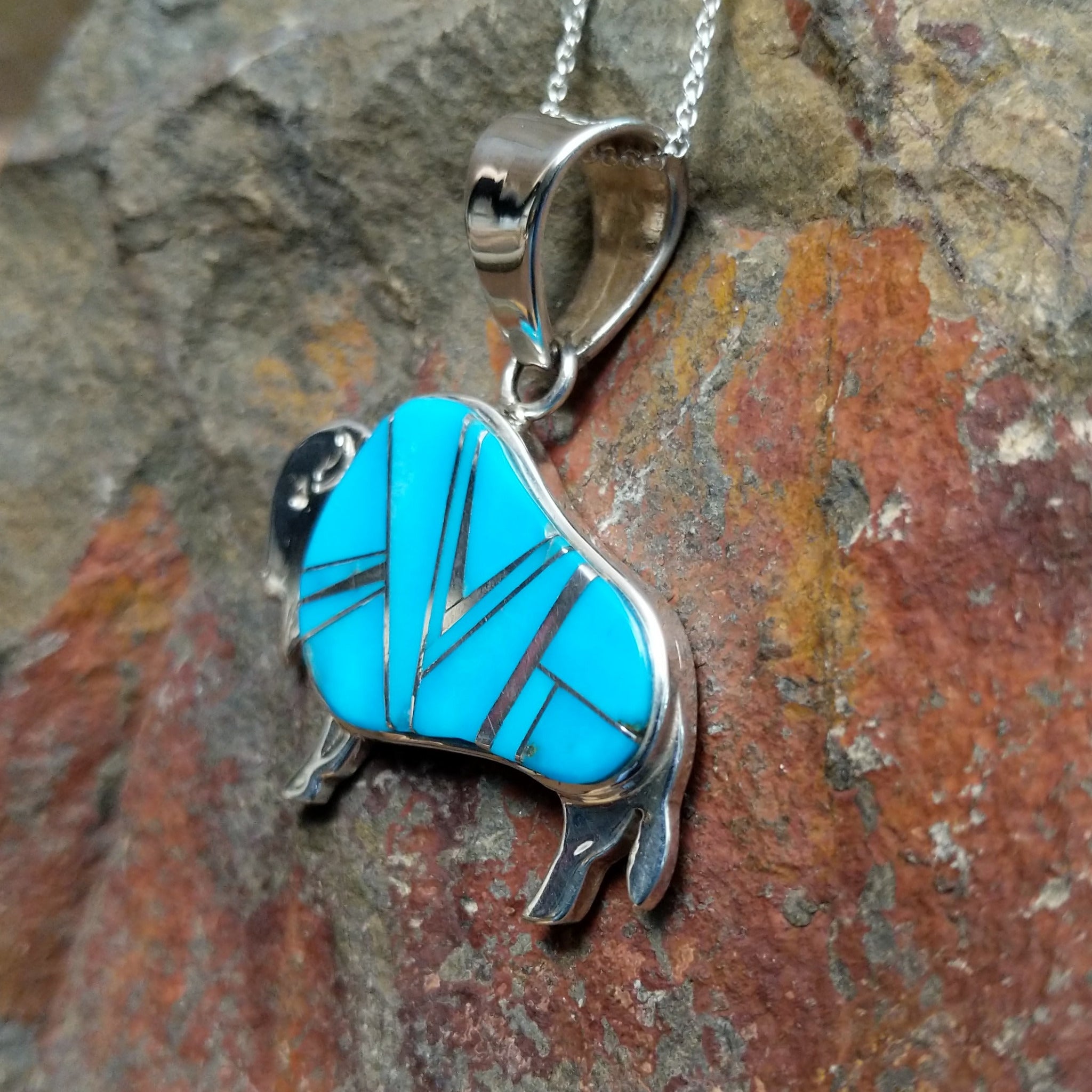 Handcrafted sterling silver turquoise buffalo inlay pendant by Evangie David, featuring a traditional buffalo design; side view.