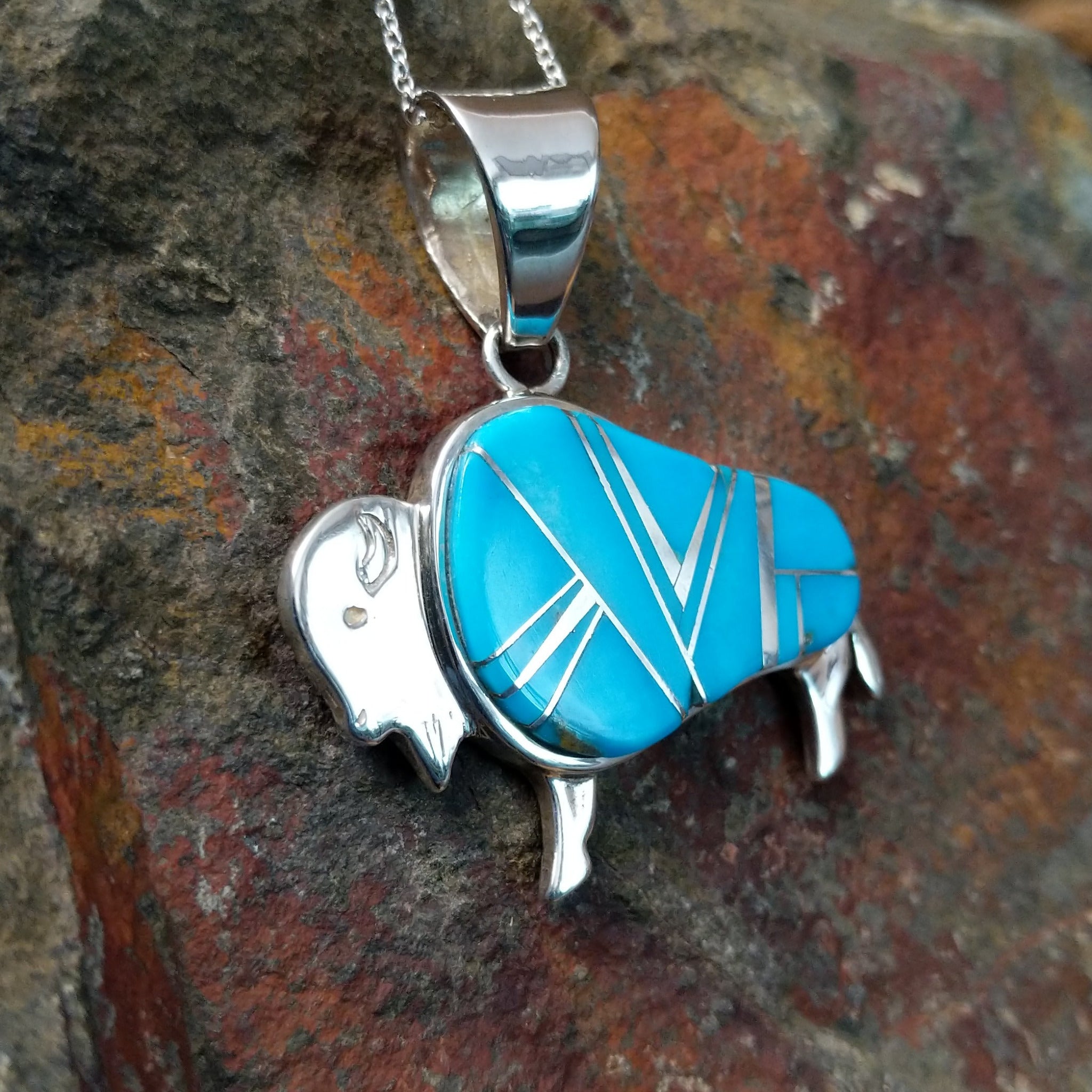 Handcrafted sterling silver turquoise buffalo inlay pendant by Evangie David, featuring a traditional buffalo design; side view.