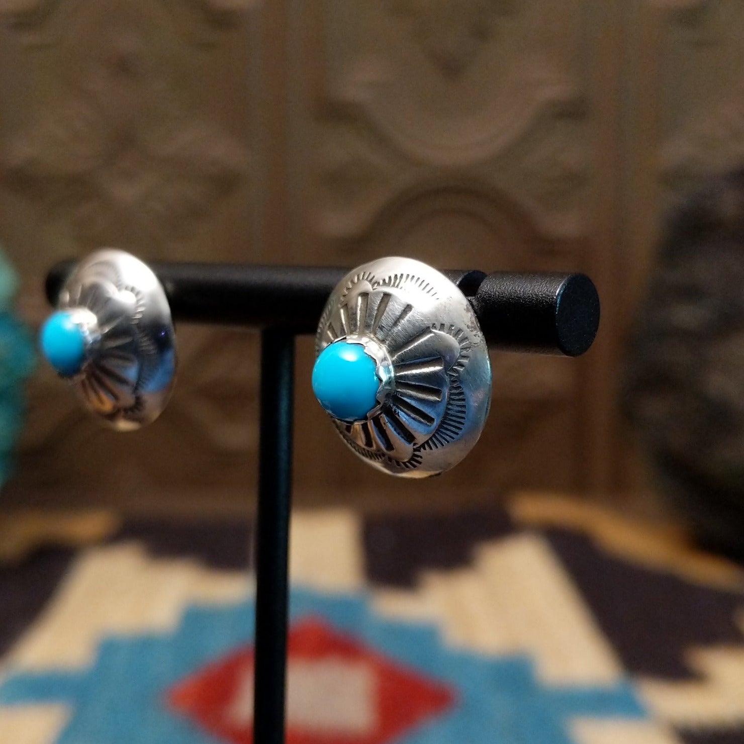Sterling silver earrings with turquoise set in round bezels, framed by stamped setting.