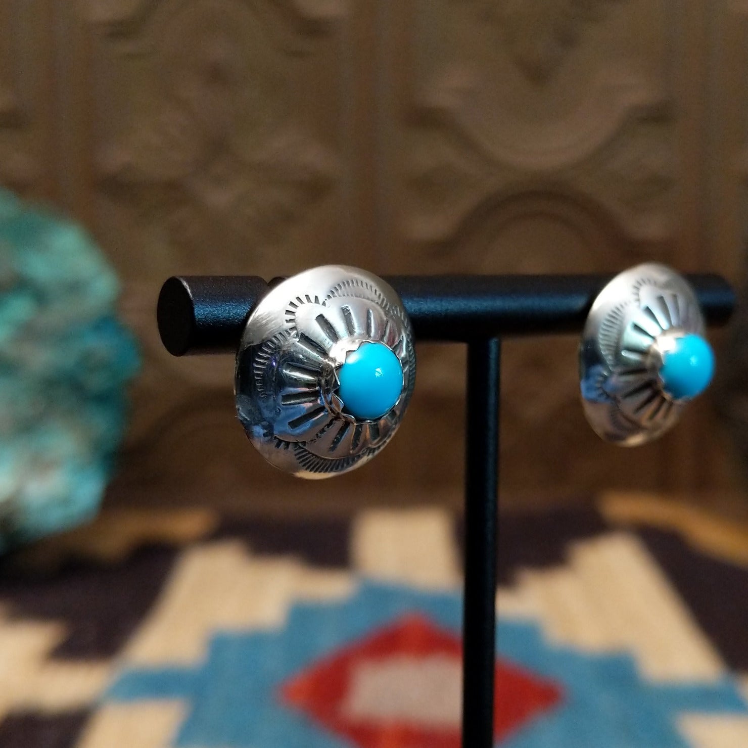 Sterling silver earrings with turquoise set in round bezels, framed by stamped setting.