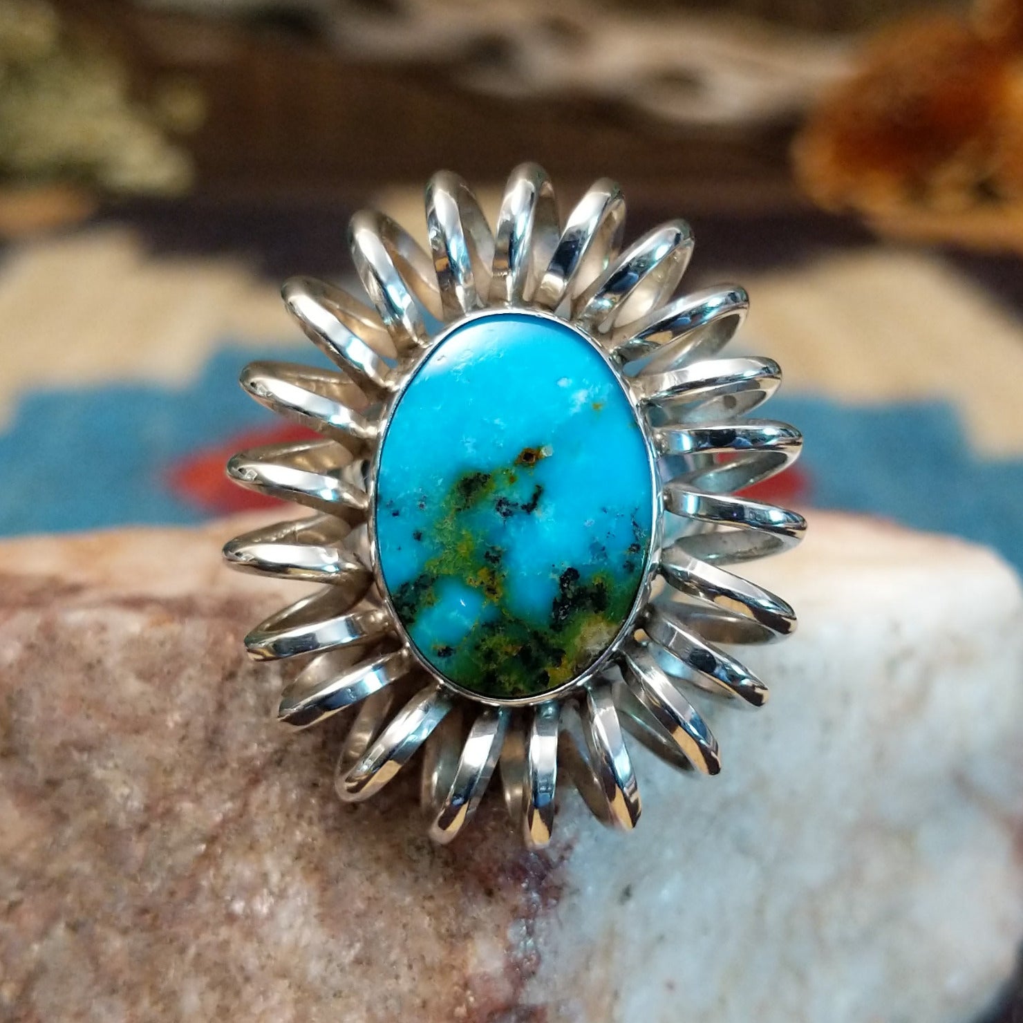 Sterling silver ring with turquoise set in the large oval bezel, framed by coiled silverwork.