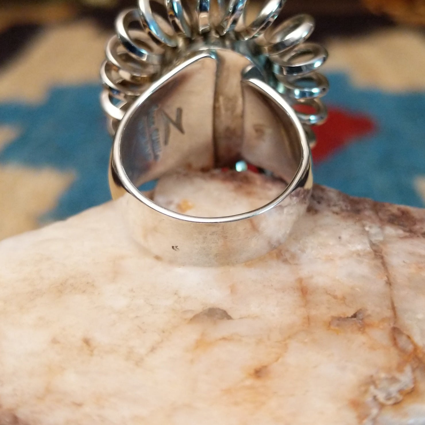 Sterling silver ring with turquoise set in the large oval bezel, framed by coiled silverwork.