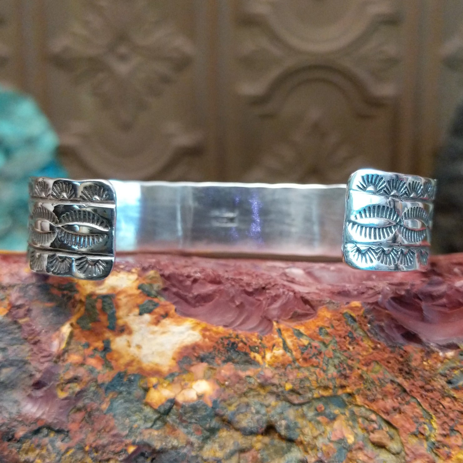 Sterling silver cuff featuring turquoise and coral set in notched bezels.