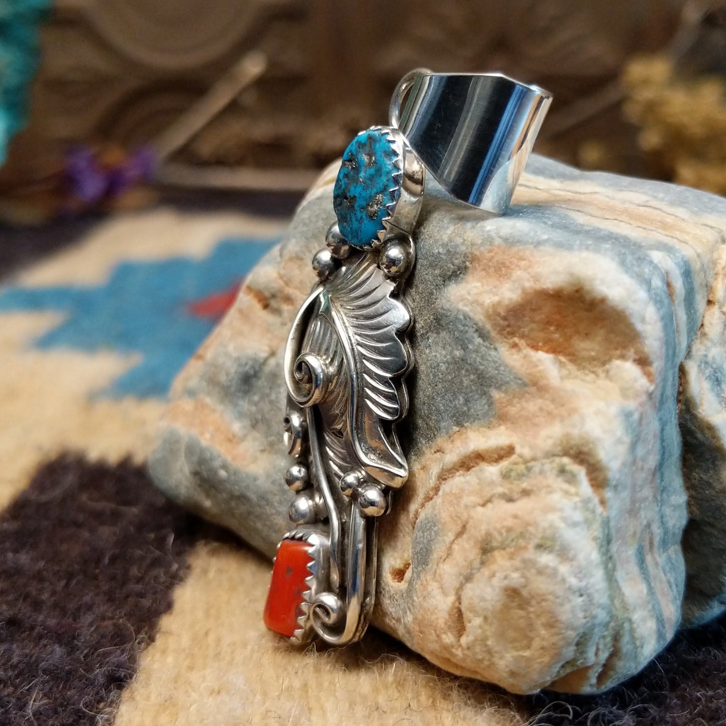 Sterling silver pendant with turquoise and coral set in notched bezels and feather silverwork.