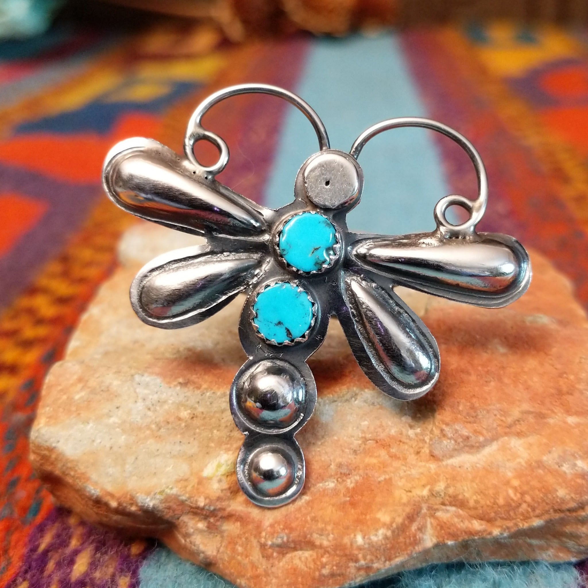 Turquoise Dragonfly Ring by Tim Yazzie featuring two turquoise stones set in Sterling Silver with polished wings, curled antennae, and dimensional silver accents.