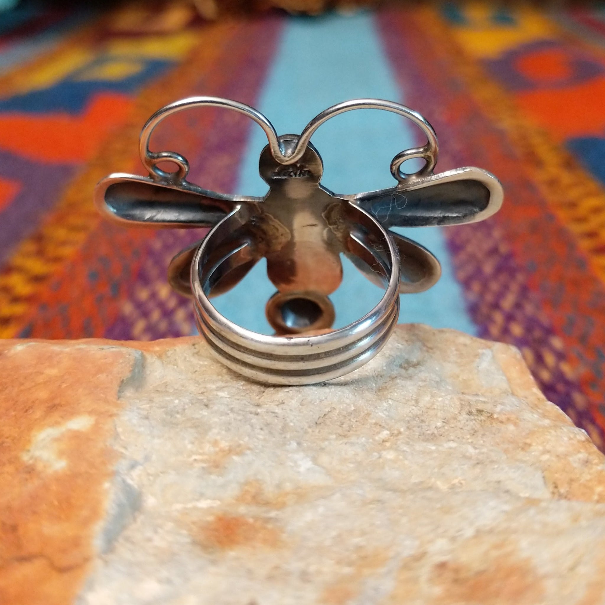 Turquoise Dragonfly Ring by Tim Yazzie featuring two turquoise stones set in Sterling Silver with polished wings, curled antennae, and dimensional silver accents; underside view.