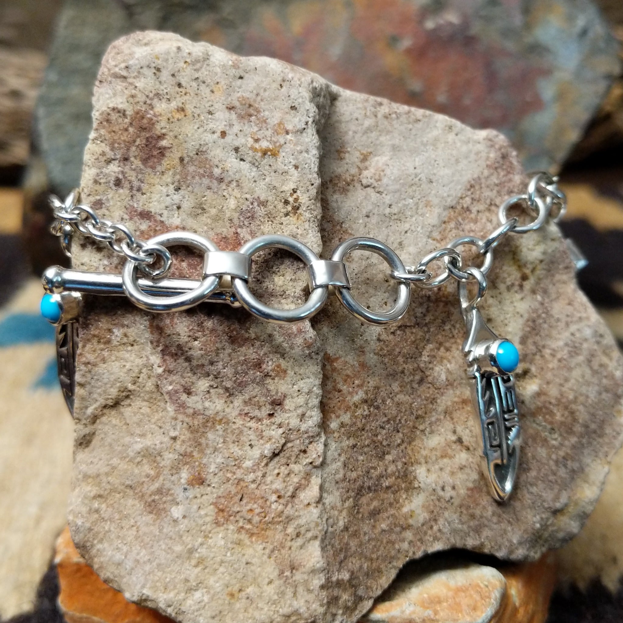 Turquoise feather charm bracelet by Elgin Tom with sterling silver feathers and natural turquoise accents; clasp view.
