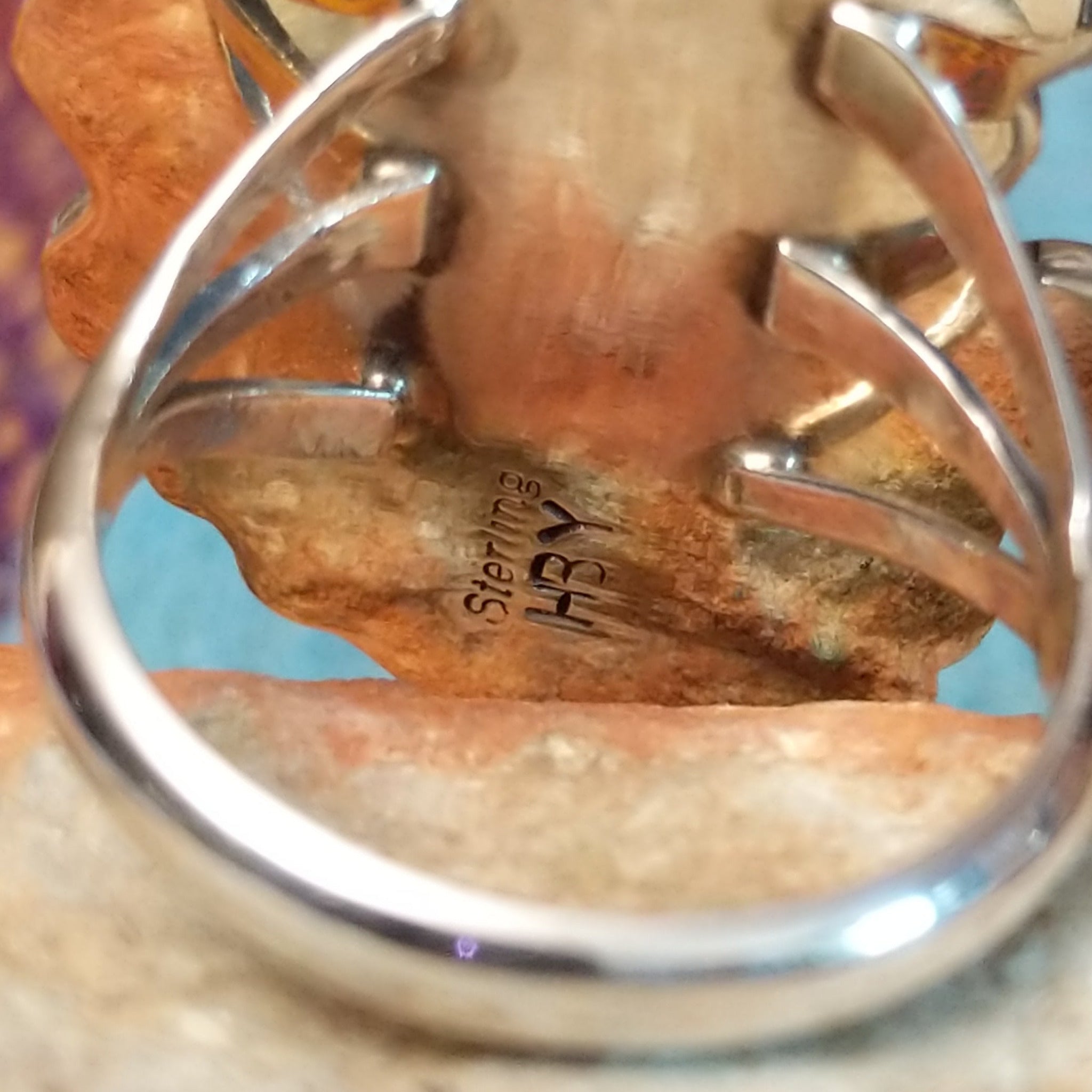 Turquoise Feather Ring by Harry B. Yazzie featuring two turquoise stones set in Sterling Silver with detailed feathers, a silver flower, scrollwork, and polished bead accents; artisan and Sterling Silver stamp.