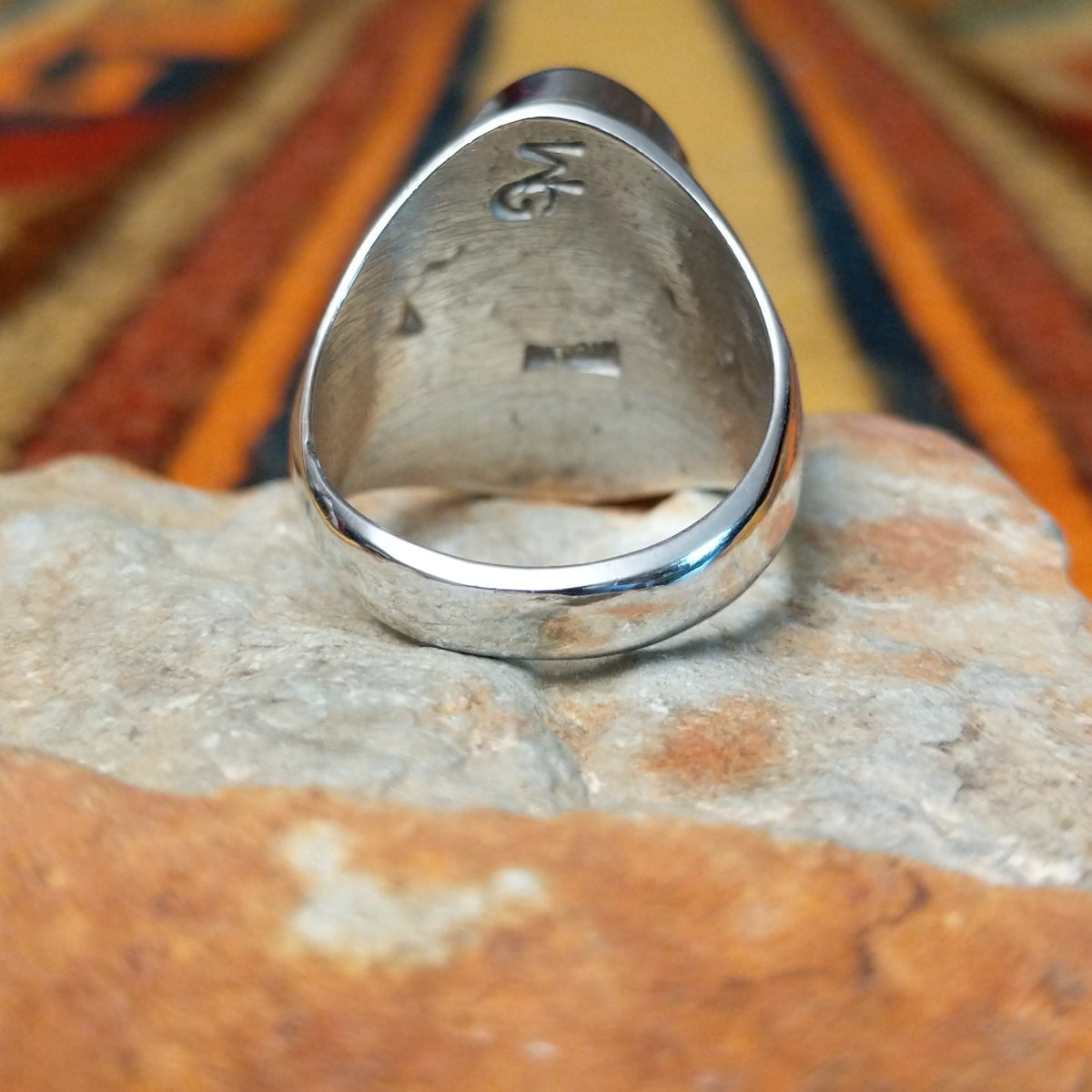 This striking Turquoise Inlay Ring by Wilbert Grey features a large oval face with vibrant blue turquoise, geometric silver inlay lines, natural dark matrix, and a polished silver band; underside view.