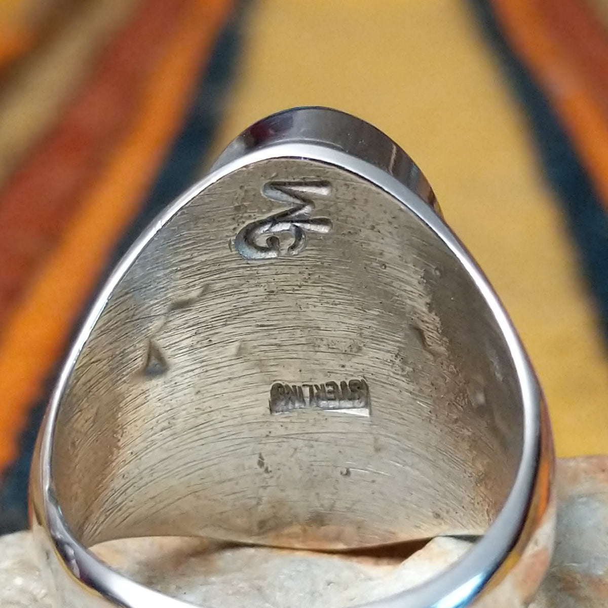 This striking Turquoise Inlay Ring by Wilbert Grey features a large oval face with vibrant blue turquoise, geometric silver inlay lines, natural dark matrix, and a polished silver band; artisan and Sterling Silver stamp.