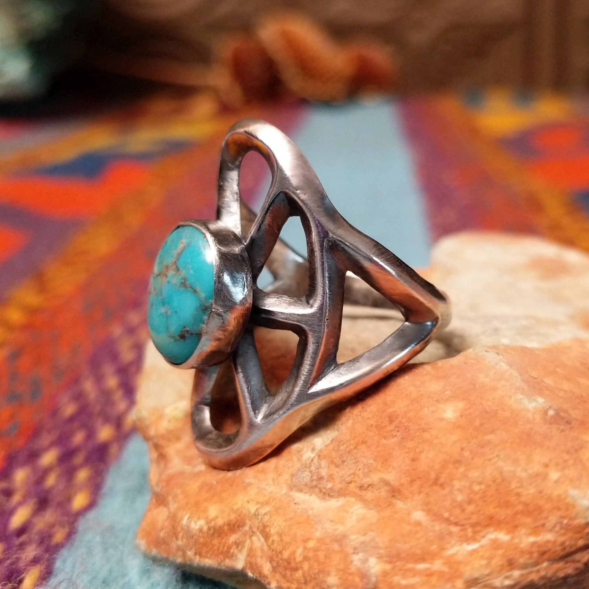 Turquoise Lattice Ring by Harry Morgan featuring an oval turquoise stone with natural matrix set in Sterling Silver, surrounded by bold sculpted lattice-style openwork; side view.