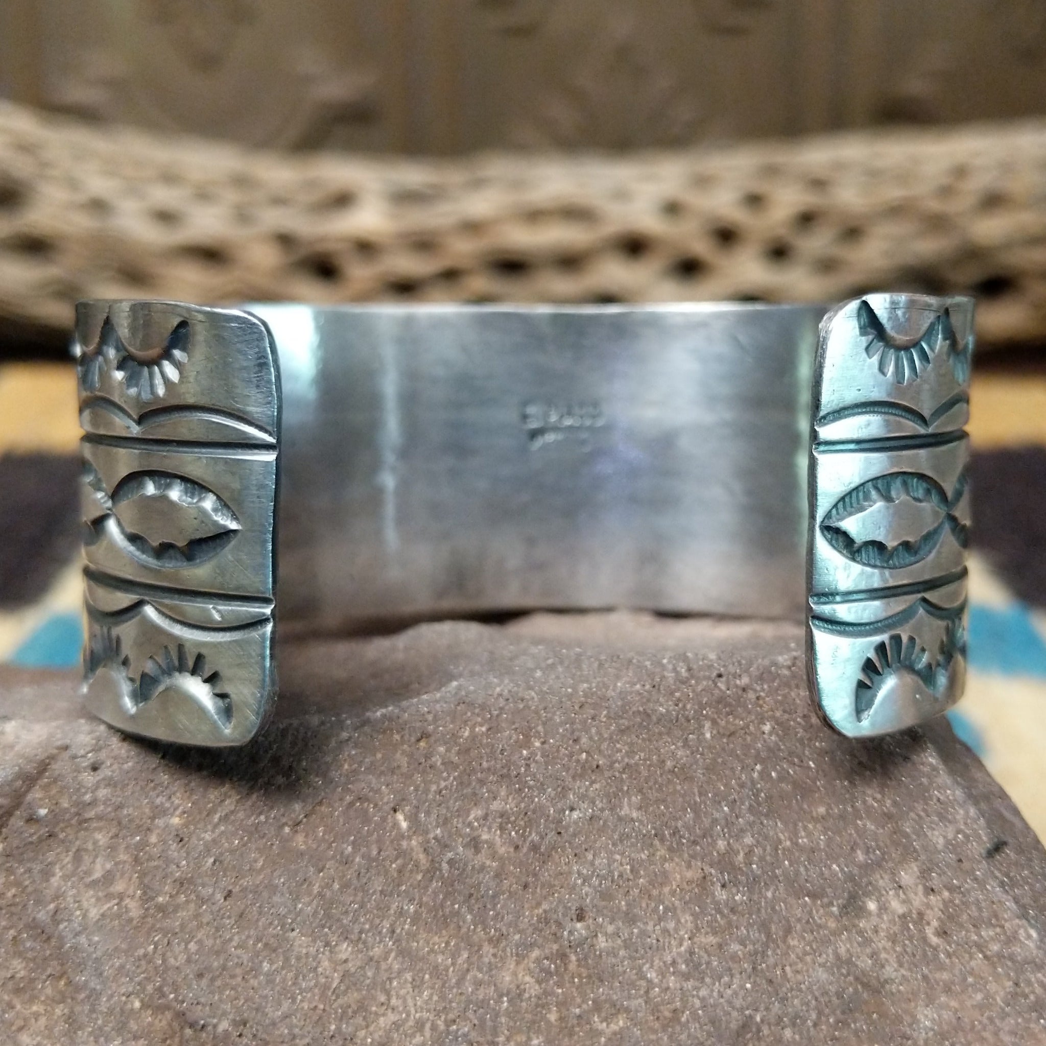 Turquoise Mountain turquoise cuff by E. Piaso, featuring a blue turquoise stone with a natural brown matrix set in a handcrafted wide sterling silver cuff; underside view.