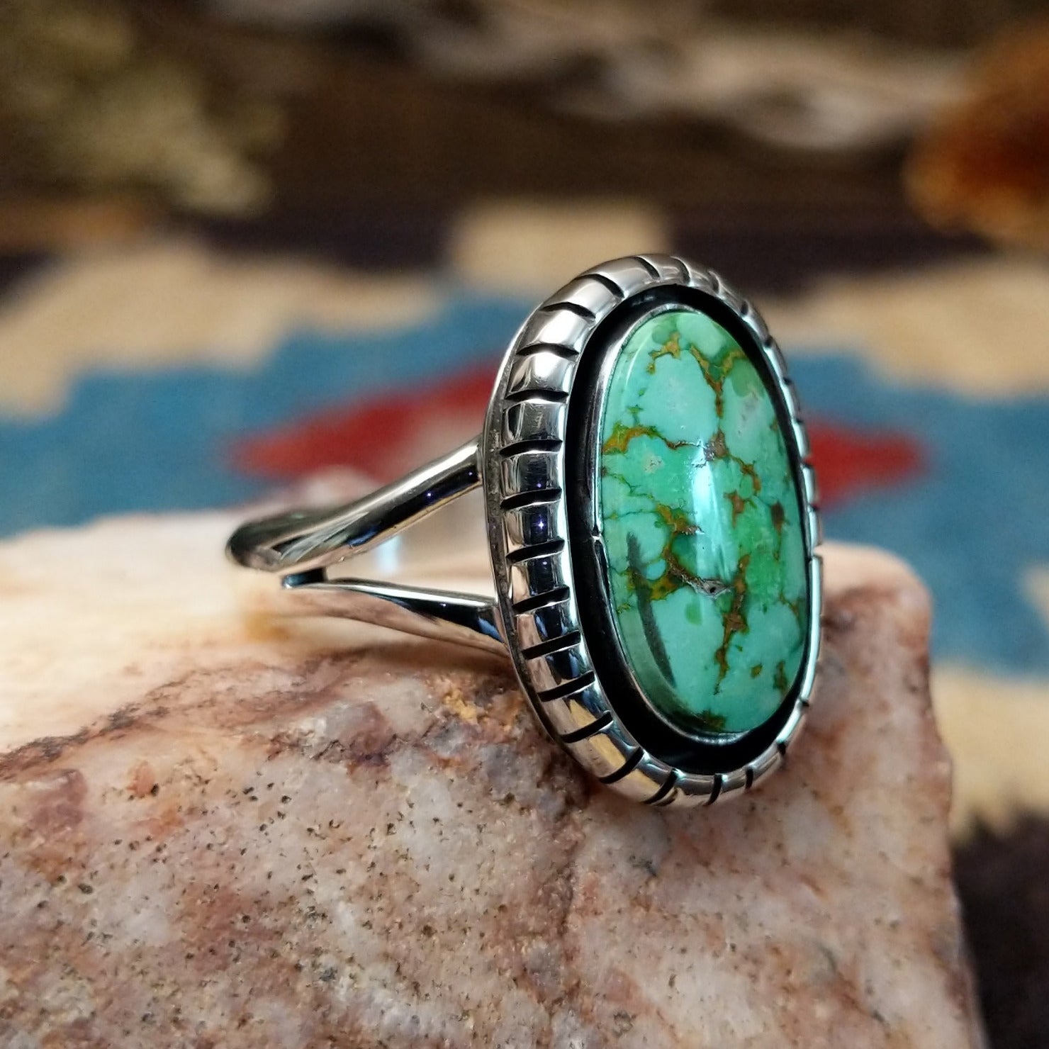 Sterling silver ring with turquoise set in the oval bezel that is framed by the shadowbox setting.