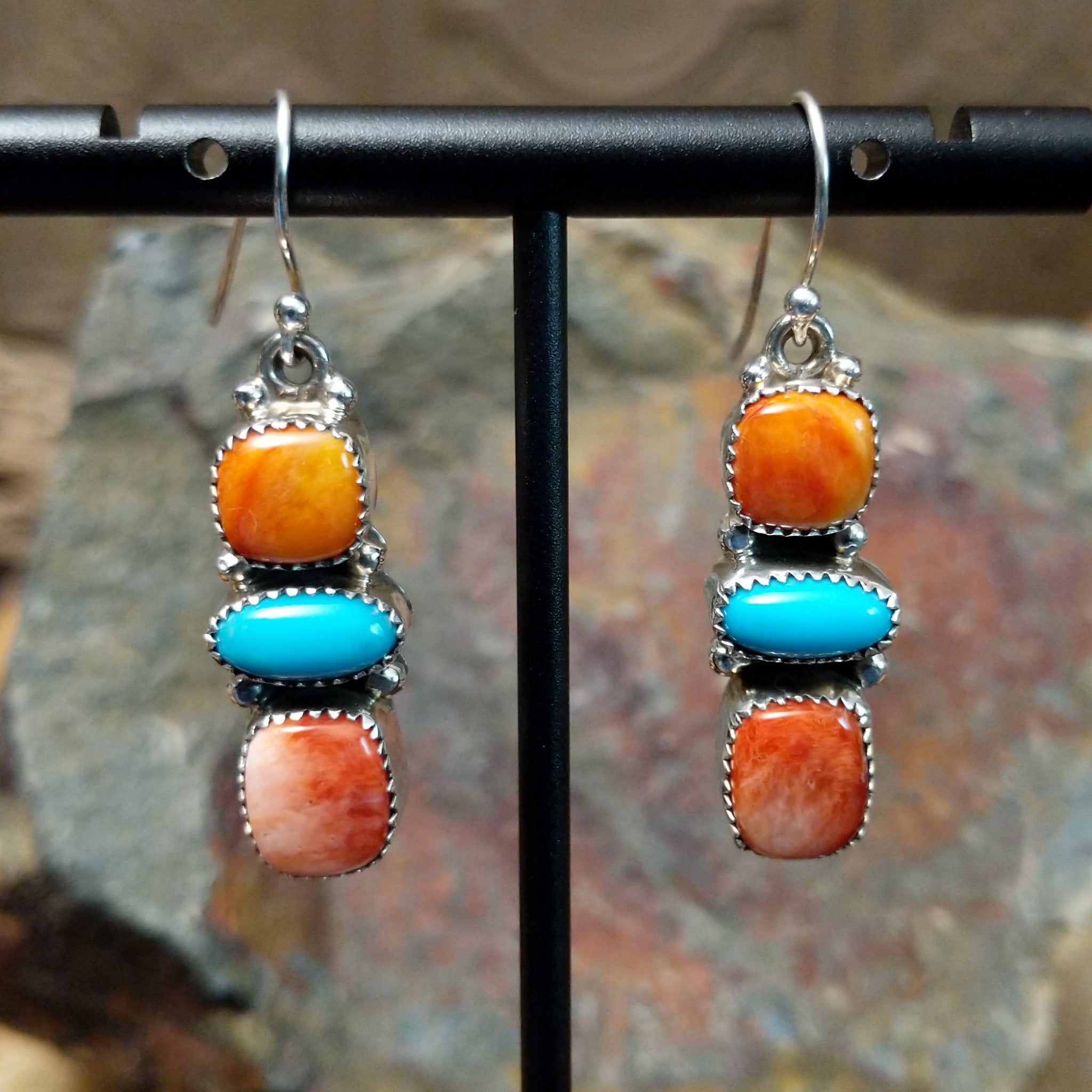 Handcrafted sterling silver turquoise and spiny oyster earrings by the Platero Family, featuring a three-stone dangle design with vibrant orange and blue gemstones.