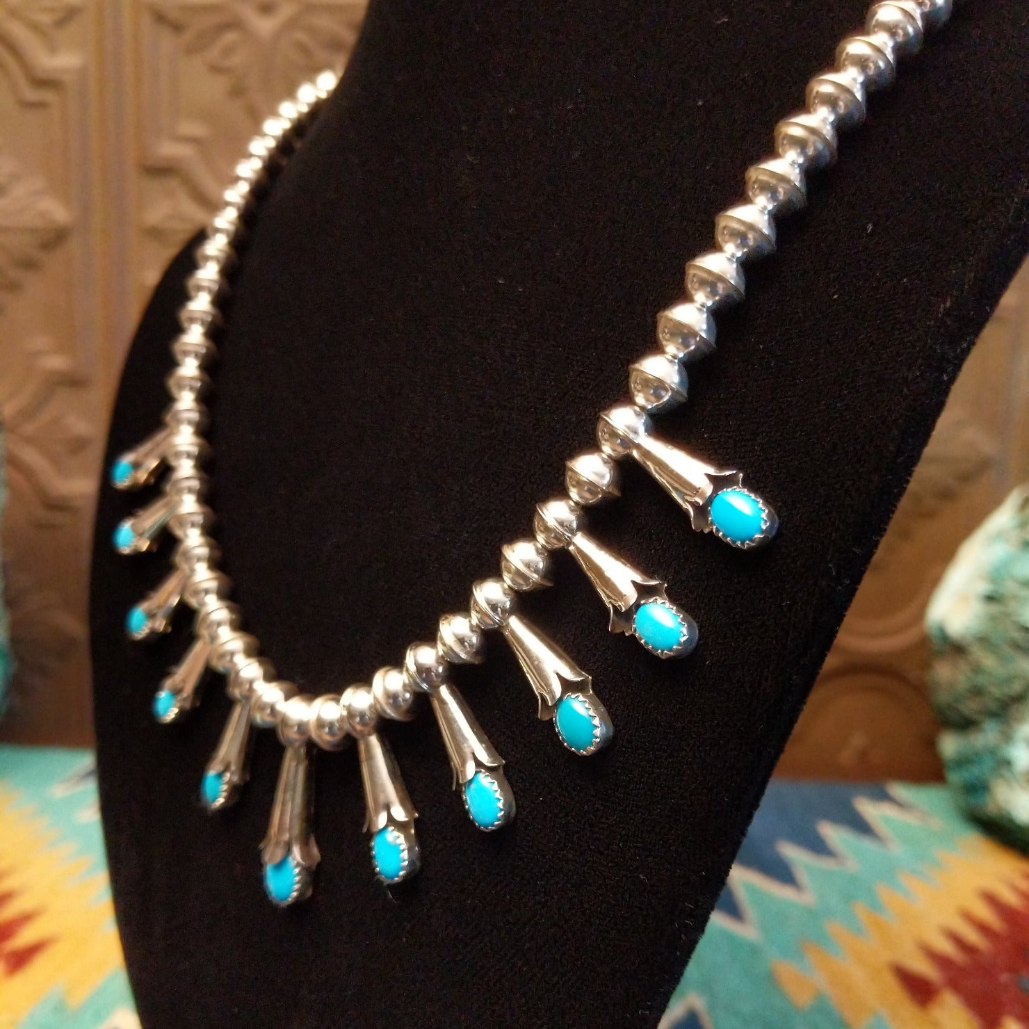 Beaded sterling silver necklace with multiple squash blossom pendants and turquoise set in notched bezels.