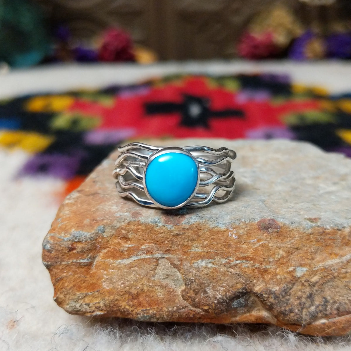 Radiant Turquoise Ring by Angela Martin featuring a round sky-blue turquoise stone set in sterling silver with flowing wave-like silver strands.