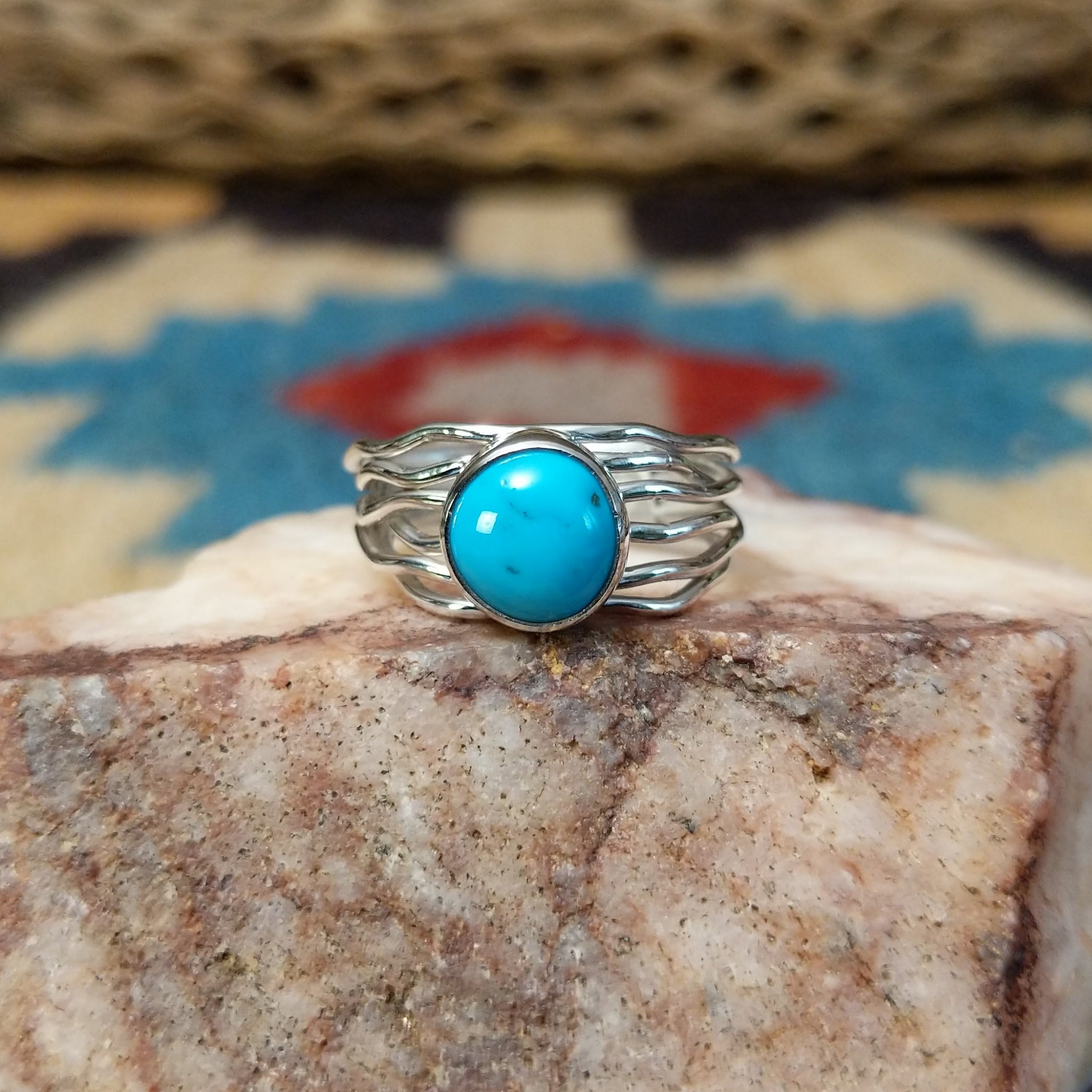 Turquoise strand ring by Angela Martin, featuring a round blue turquoise stone set in a handcrafted sterling silver multi-strand band with a polished finish.