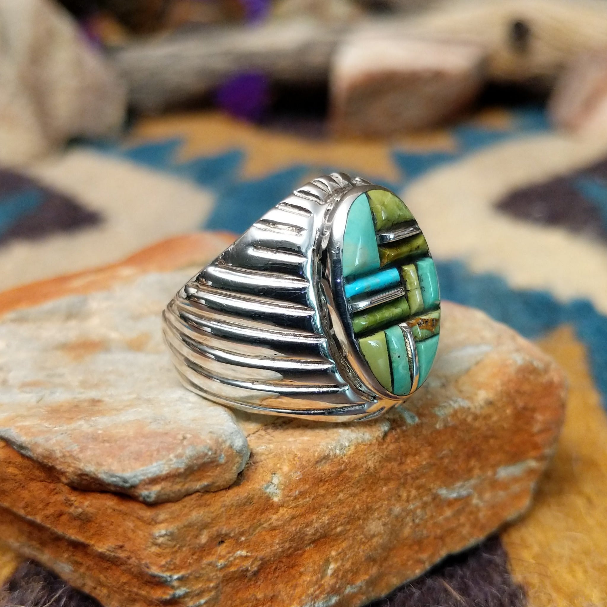 Sterling silver Turquoise inlay ring by L.C. with blue and green geometric strip inlay; side view.