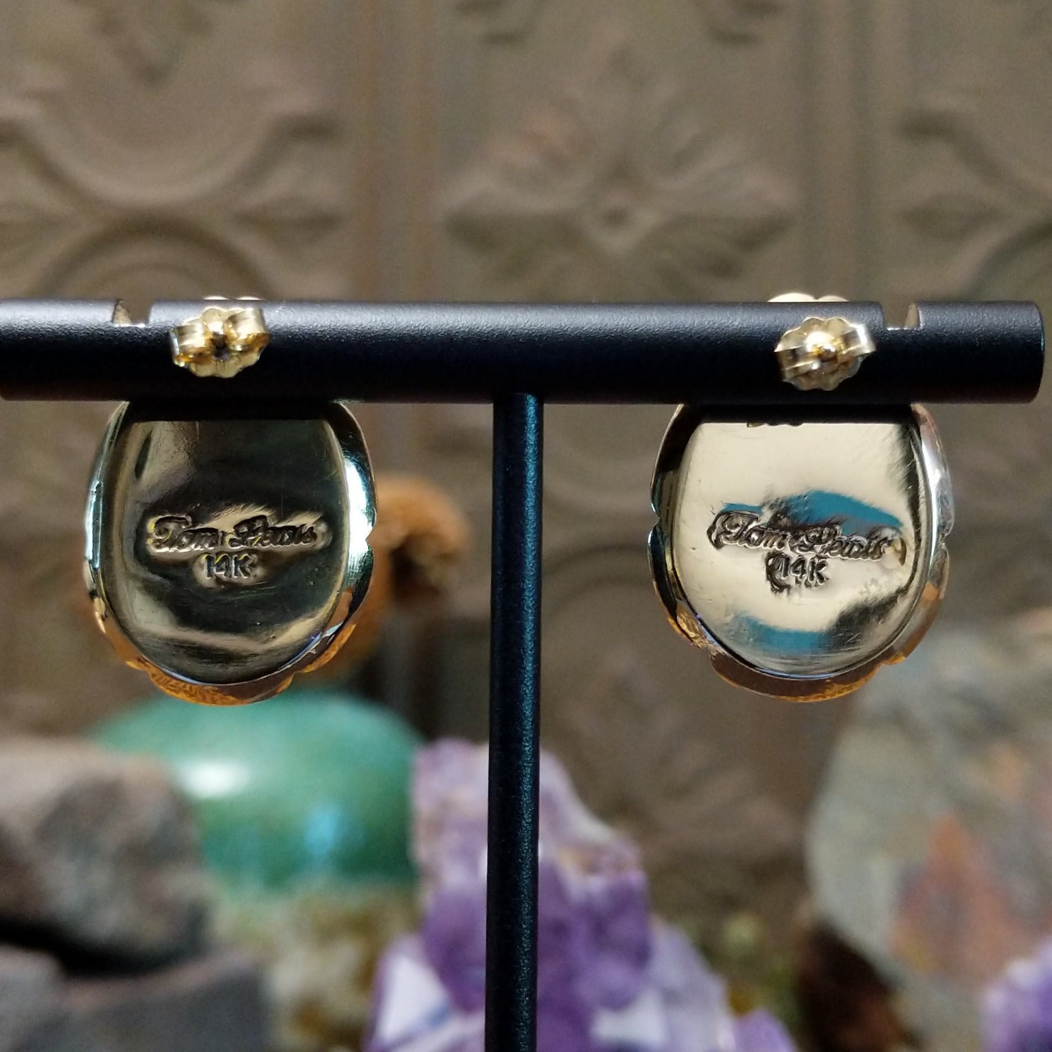 Close up of artist's stamped signature and 14K indicating 14 karat gold construction.