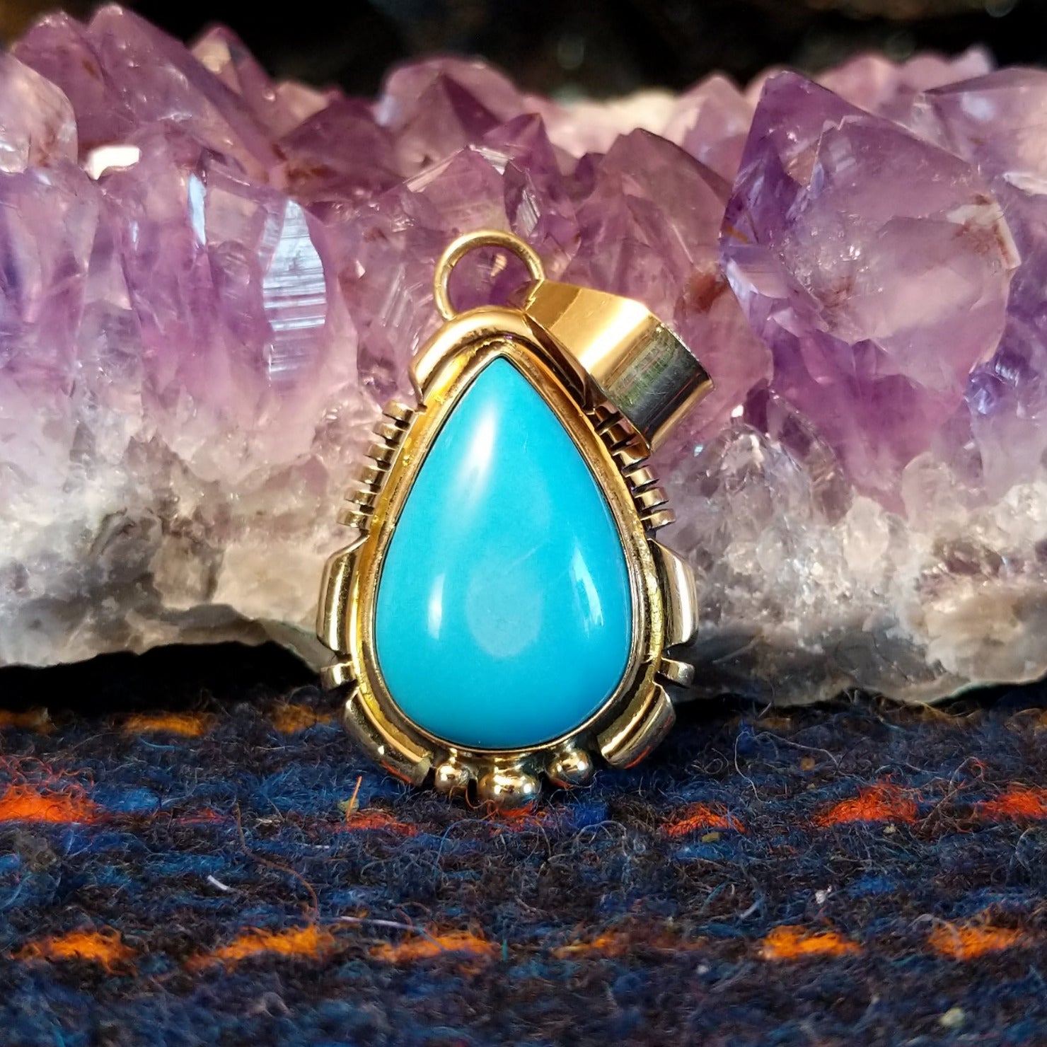 Turquoise teardrop pendant set in polished gold.