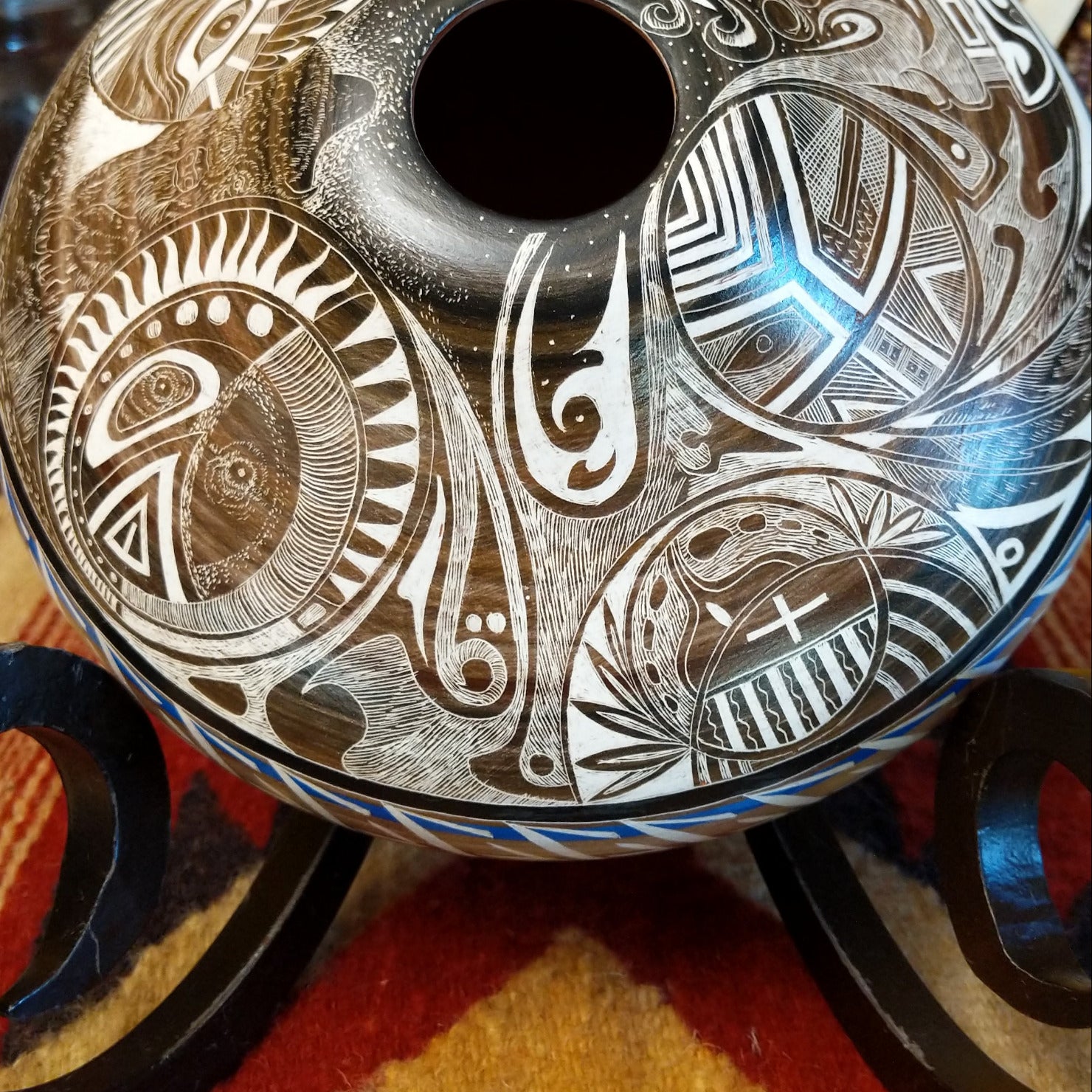 White clay with brown accents carved with detailed eyes and intricate designs.