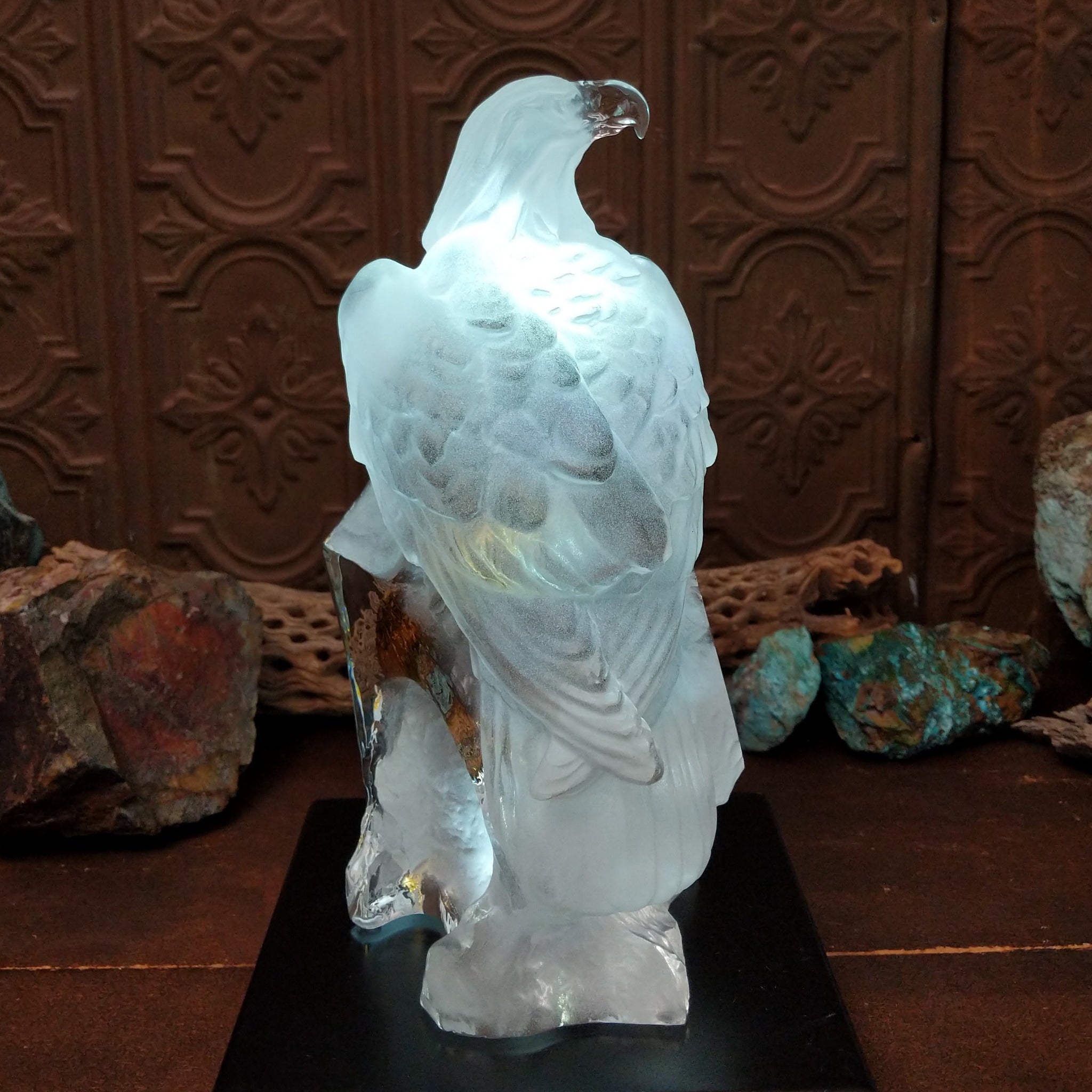 A frosted Lucite sculpture of a bald eagle with two hand-painted bald eagles soaring through the clear crystal interior; low light display.