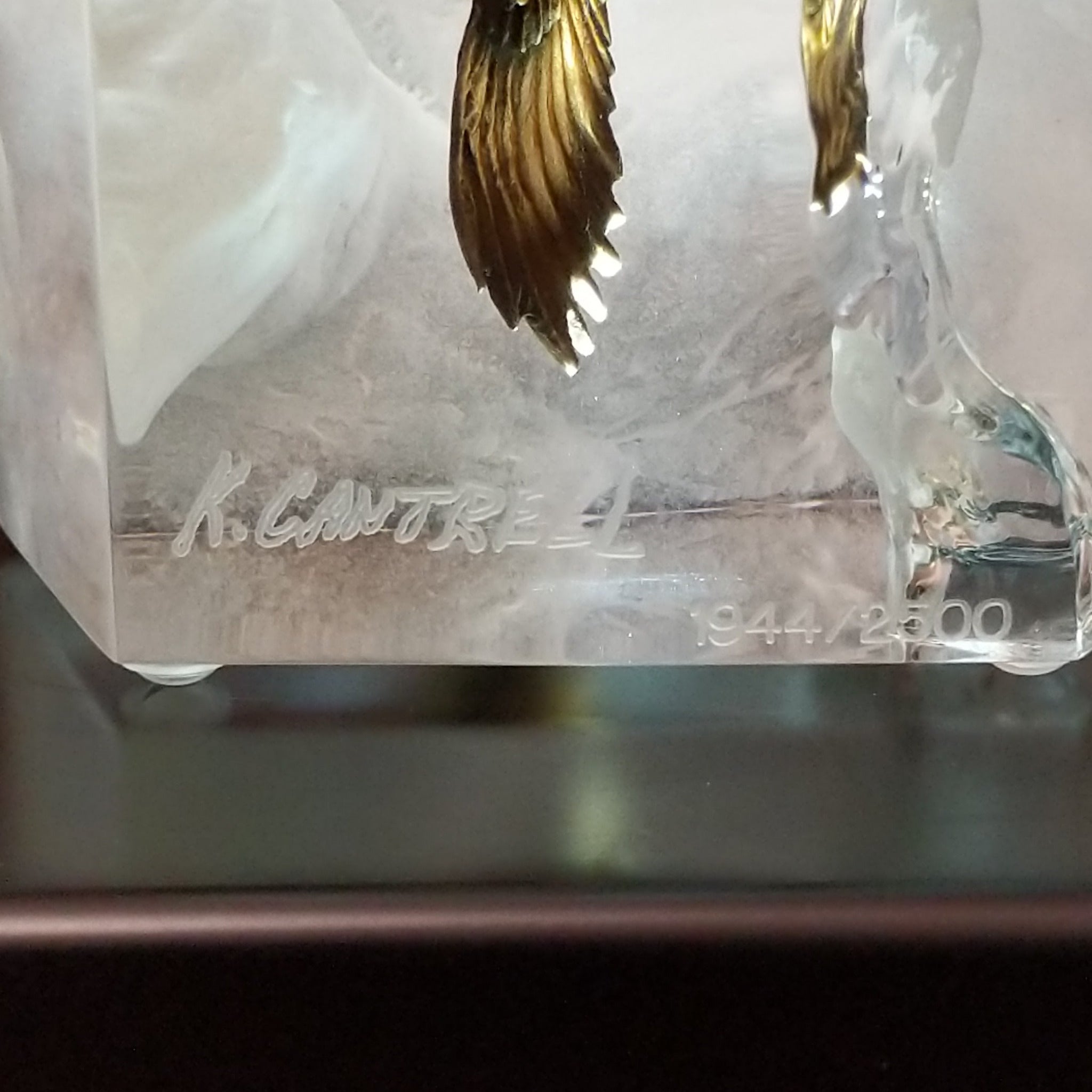 A frosted Lucite sculpture of a bald eagle with two hand-painted bald eagles soaring through the clear crystal interior; artisan signature and production number.